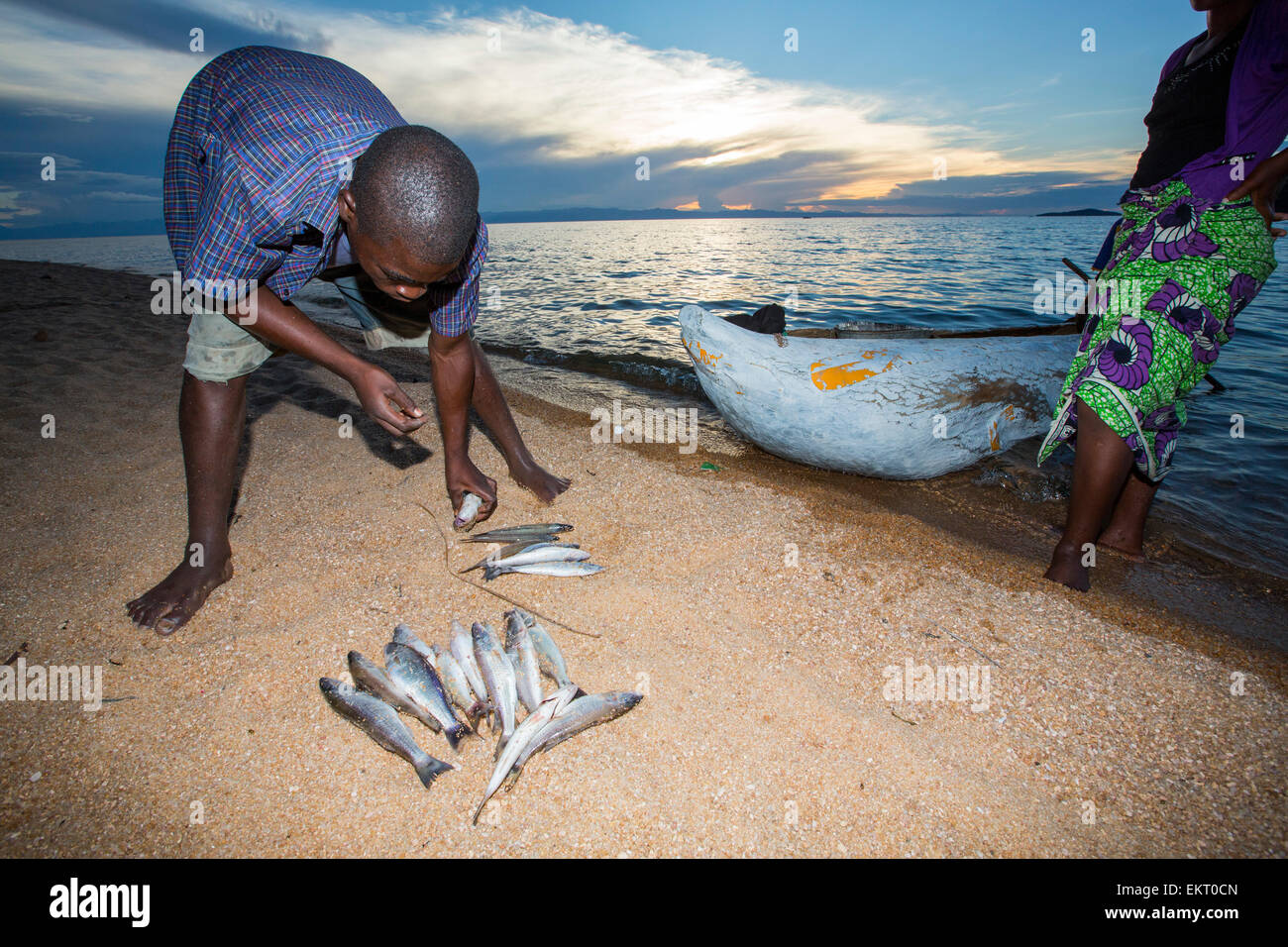 A fisherman in a traditional dug out canoe at Cape Maclear on the shores of Lake Malawi, Malawi, Africa, with his catch of fish. Stock Photo