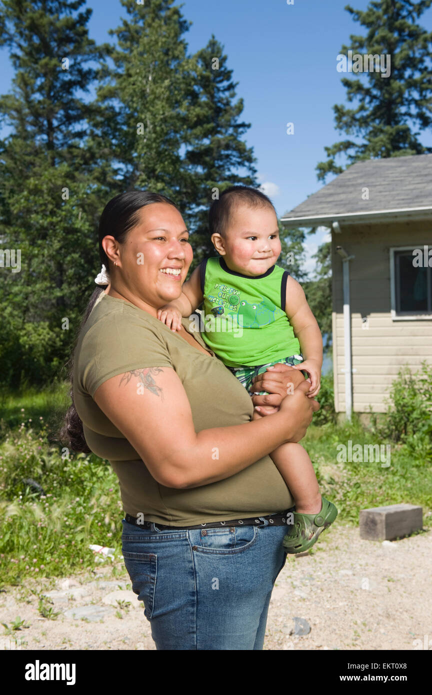 Native American Mother With Her Son Standing Outside In Front Of A Home. Stock Photo