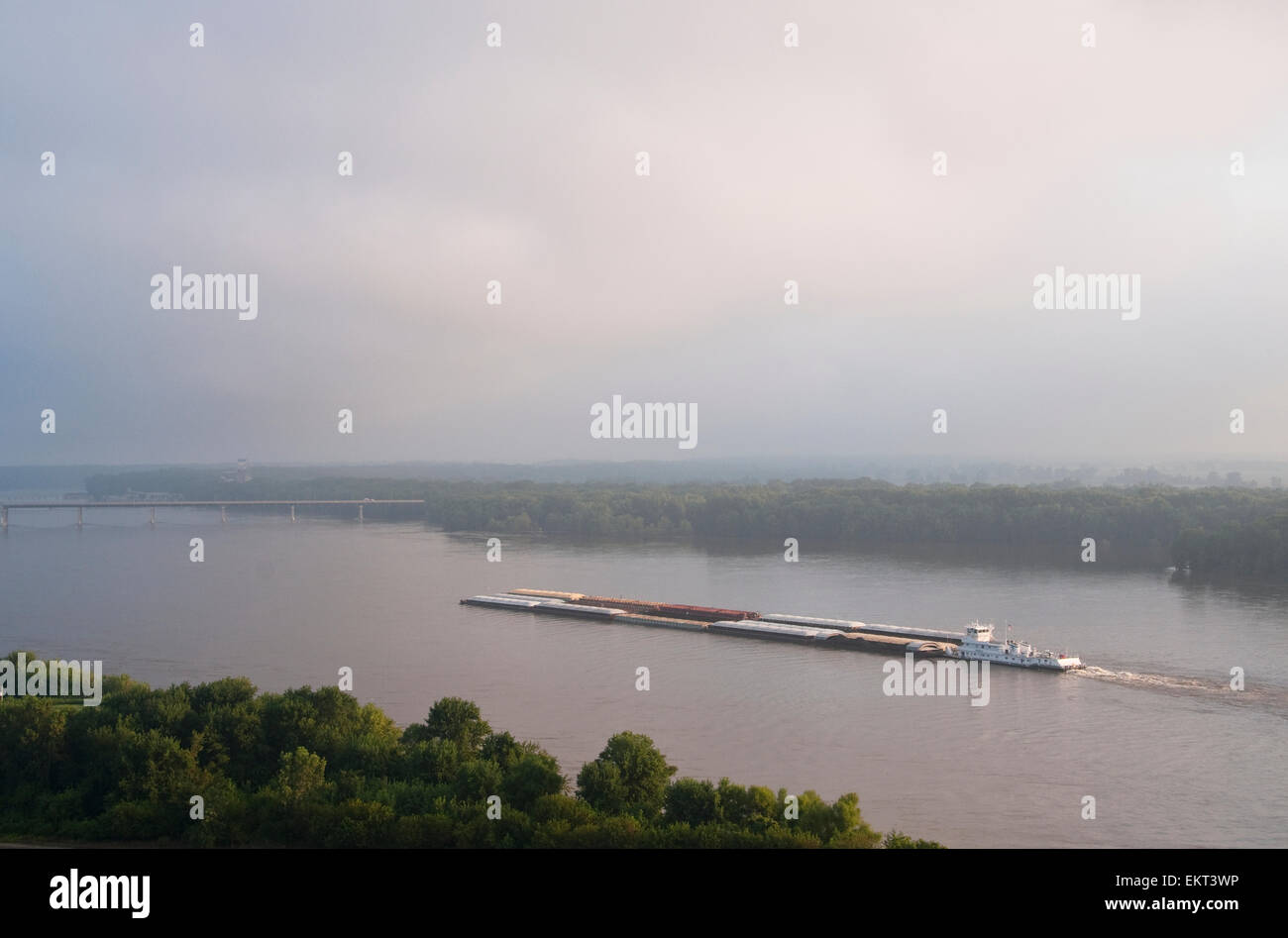 Agriculture - Grain barge navigating the Mississippi River early on an overcast morning / near Hannibal, Missouri, USA. Stock Photo