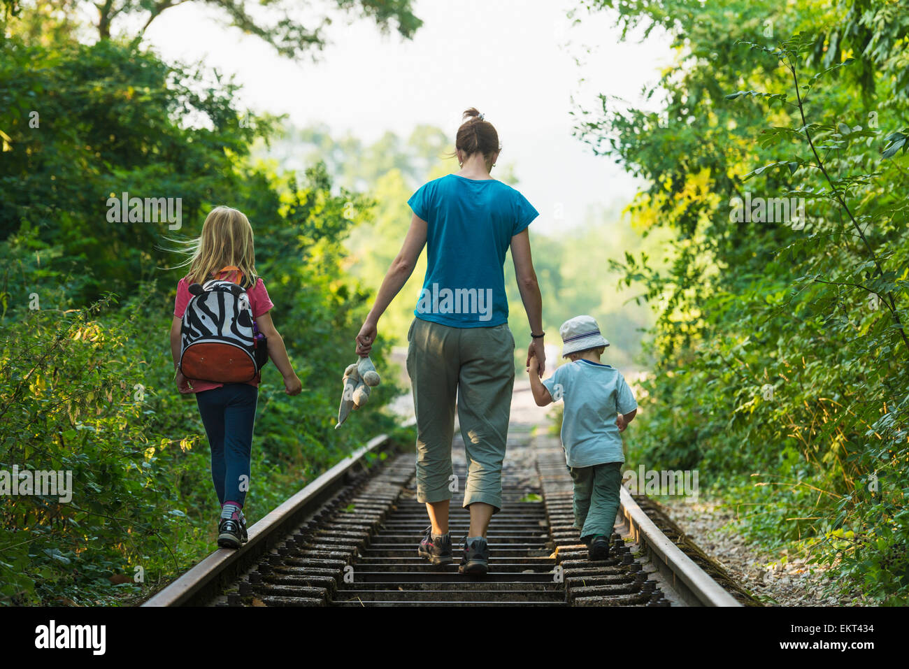Mother with boy and girl walking along abandoned railway track, near Clecy; Normandy, France Stock Photo