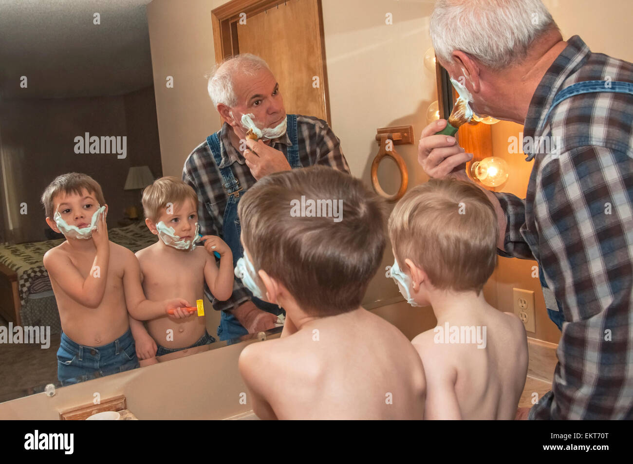 Grandfather teaching grandsons to shave Stock Photo