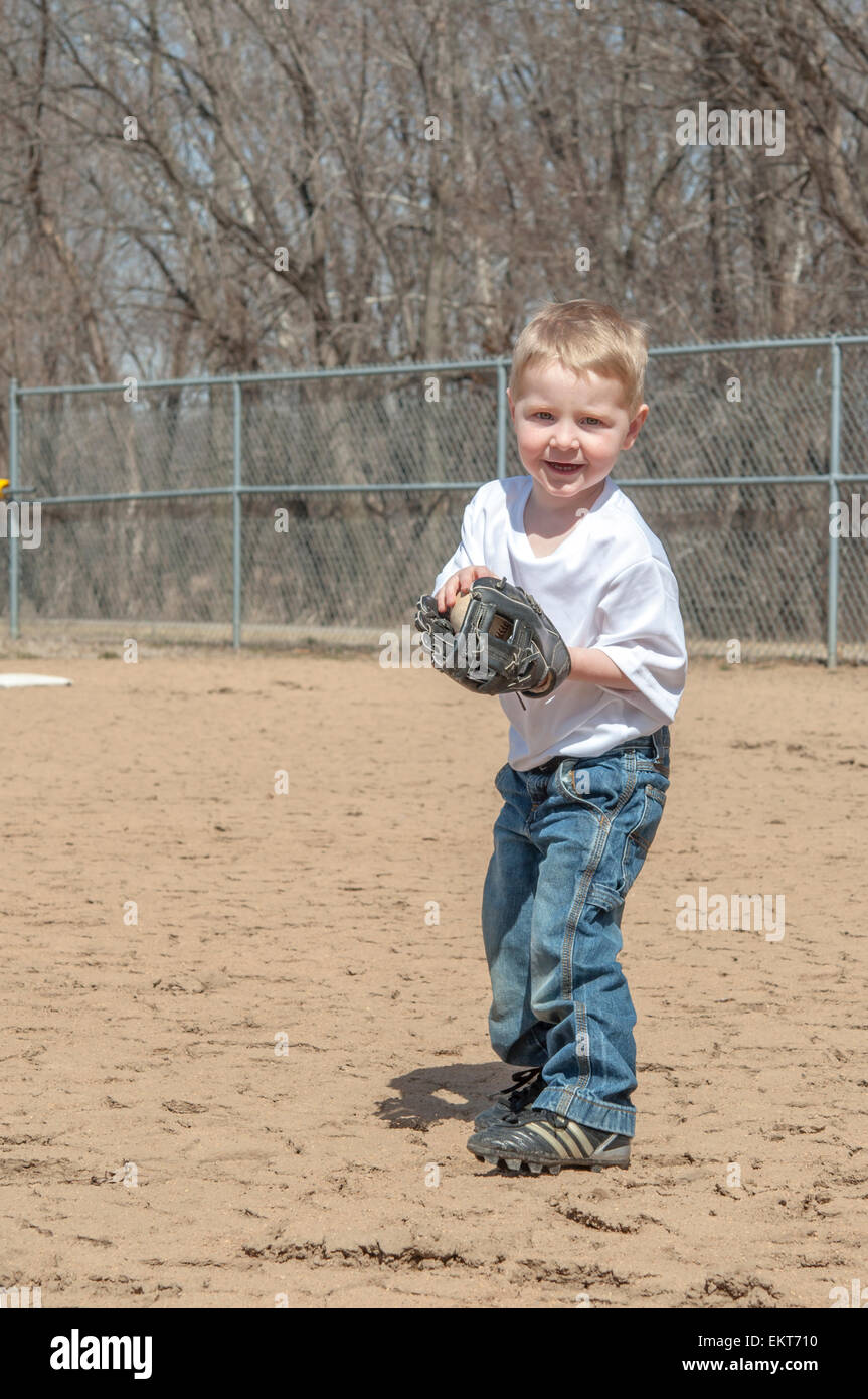 boy portrait  playing catch on baseball field with ball and glove Stock Photo