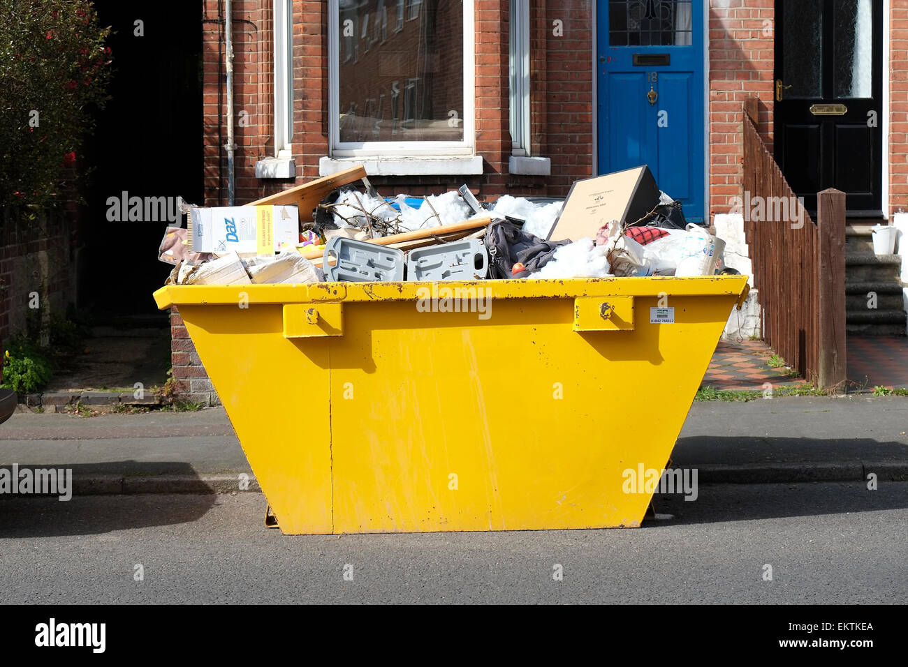 yellow rubbish skip on road outside terraced house Stock Photo Alamy