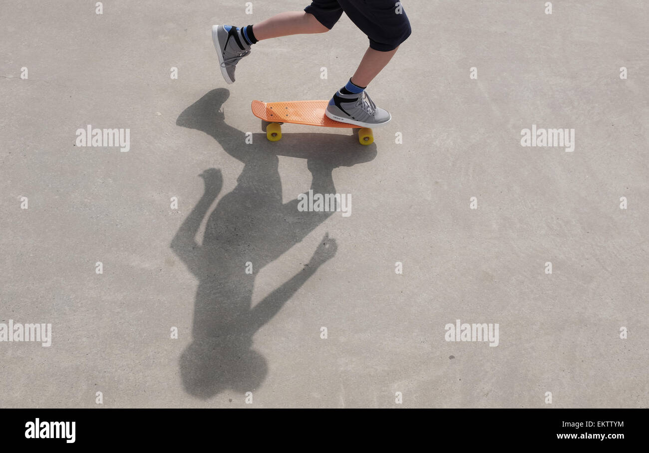 Shadow of a boy on a skateboard at skate park learning to skate in the sunshine Stock Photo