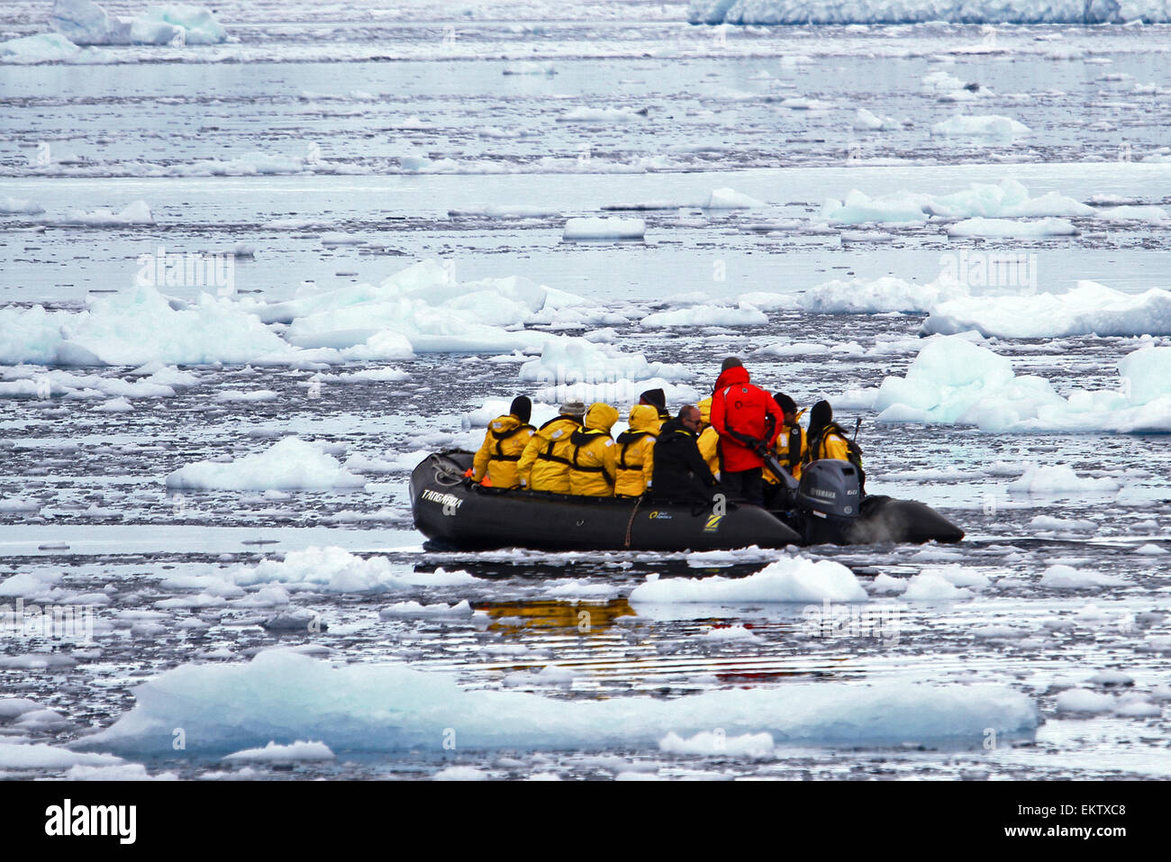 tourists on a rubber Zodiac dinghy sailing through ice in the water