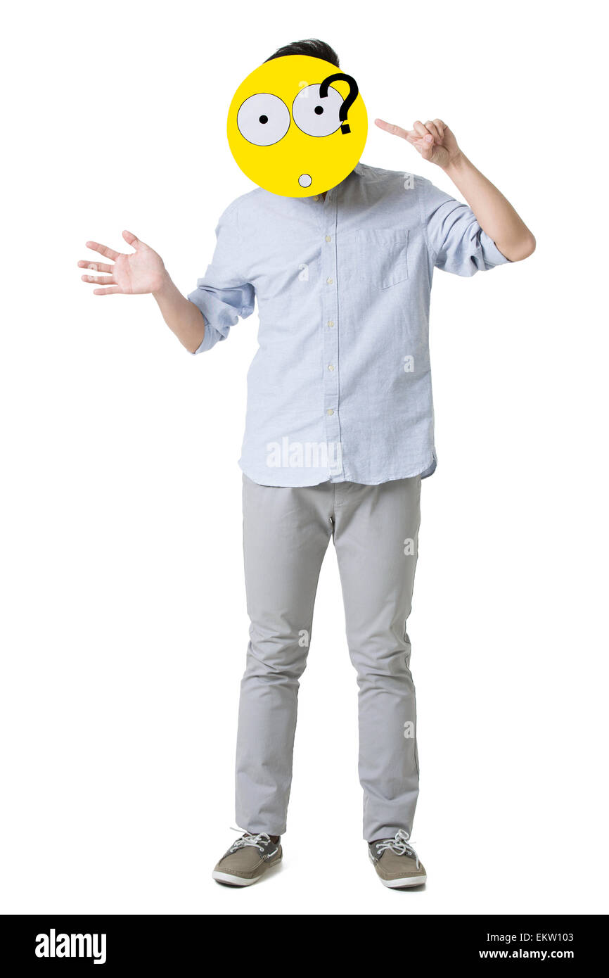 Young man with a confused emoticon face in front of his face Stock Photo