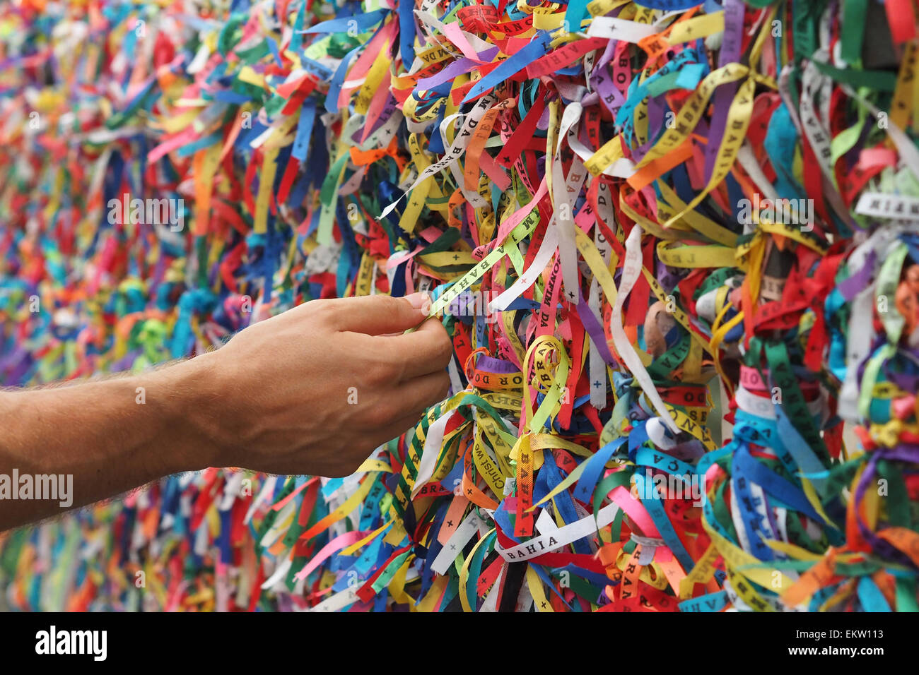 Tourist hand touching colorful Senhor do Bonfim wristbands at Pelourinho in Salvador, Bahia, Brazil. Stock Photo