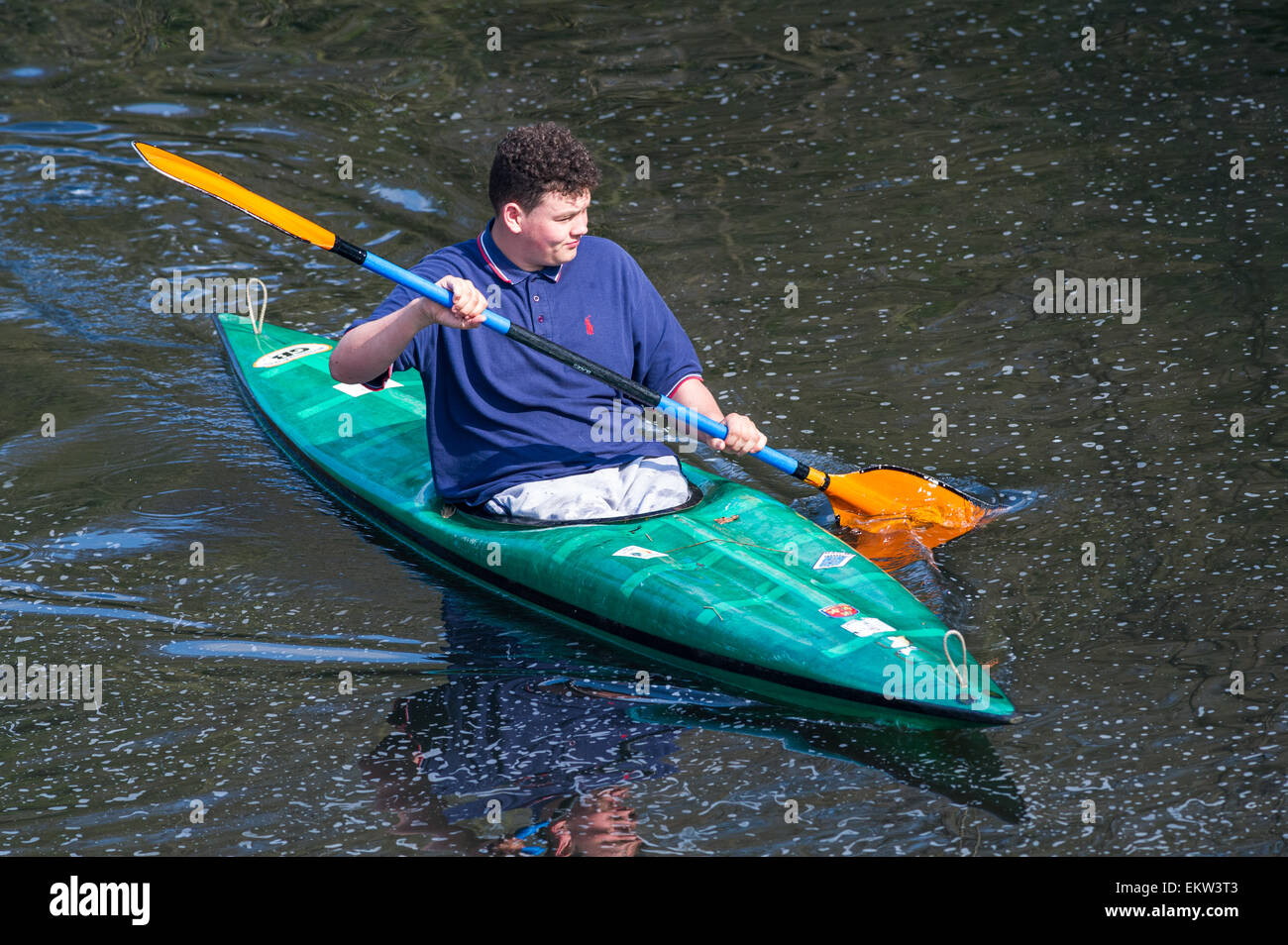 Young man canoeing in a slalom canoe wearing no helmet or life jacket