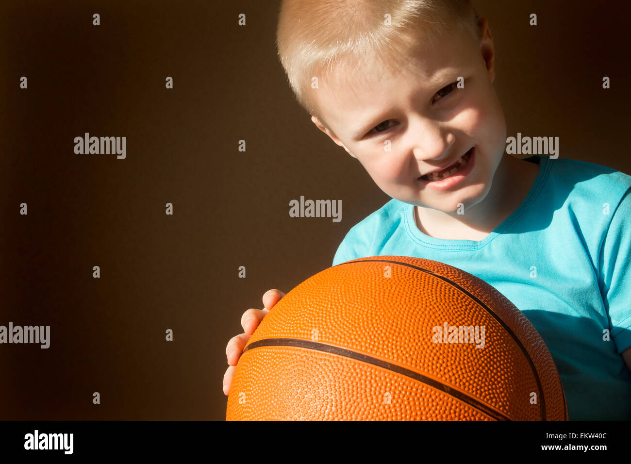 Beautiful happy little child (boy) with basketball, close up horizontal portrait with copy space Stock Photo