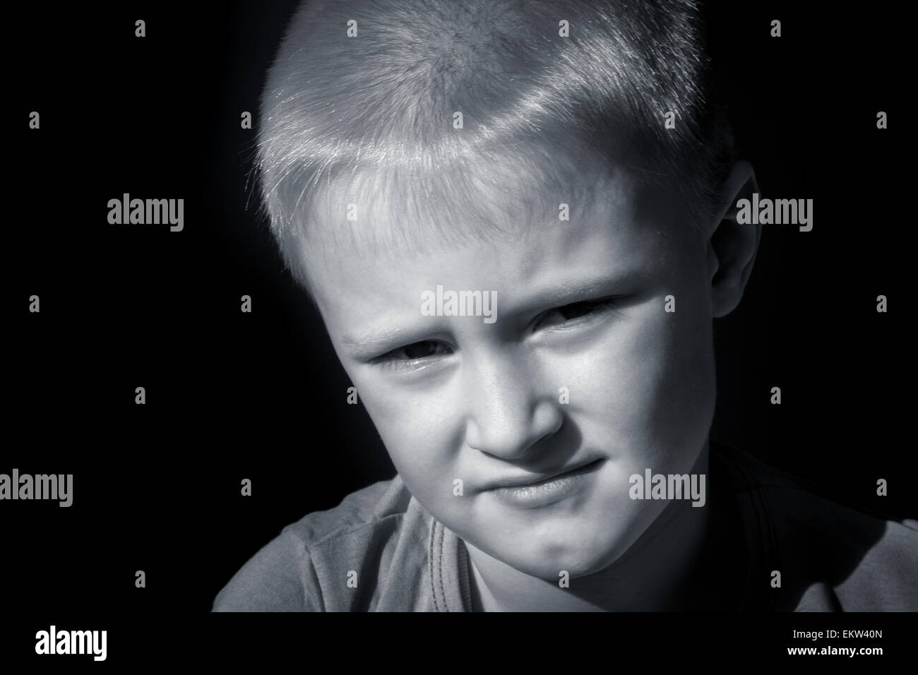 Upset abused frightened little child (boy),  close up horizontal dark portrait with copy space Stock Photo