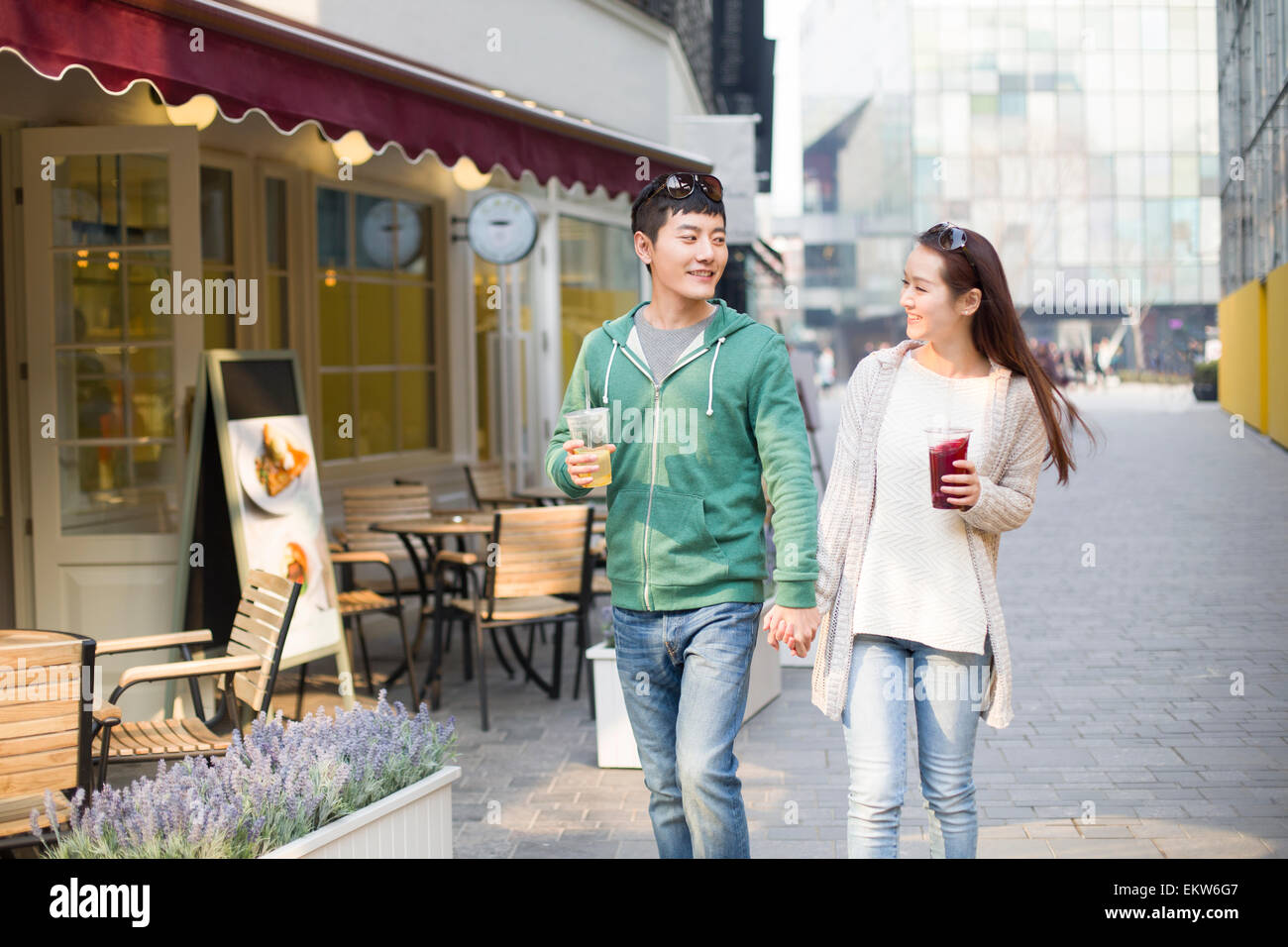 Young couple holding hands walking Stock Photo - Alamy