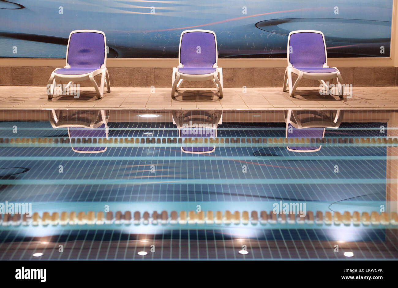 Detail of an empty swimming pool at a central London fitness centre. Smooth water,  floating lane dividers and empty loungers Stock Photo