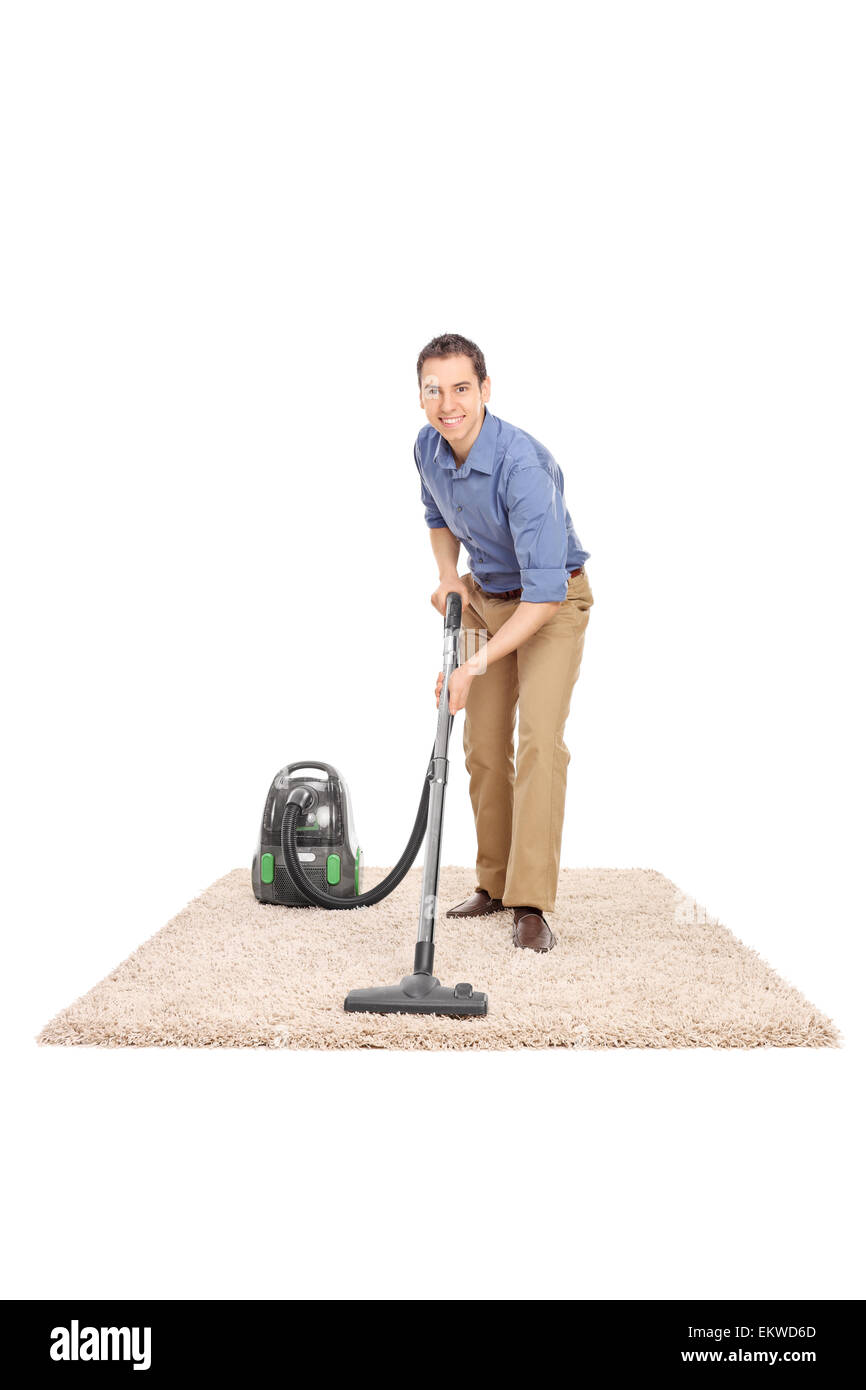 Full length portrait of a cheerful young man cleaning with a vacuum cleaner and looking at the camera Stock Photo