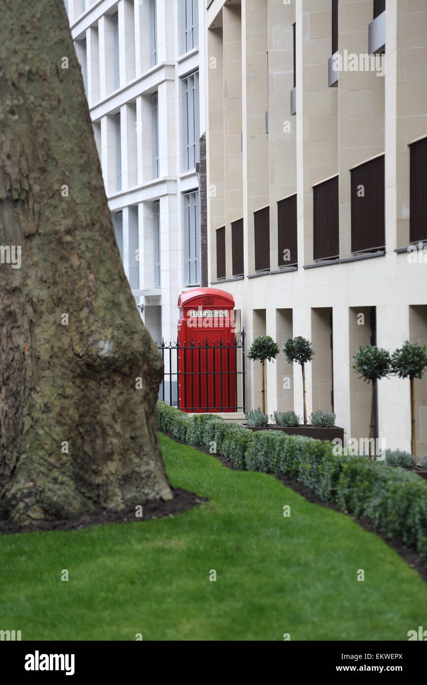 A traditional red London telephone box on Fetter Lane in the city of London - framed by newly installed landscape gardens Stock Photo