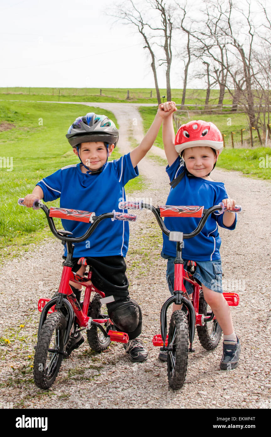 Two boys with helmets on matching bikes Stock Photo