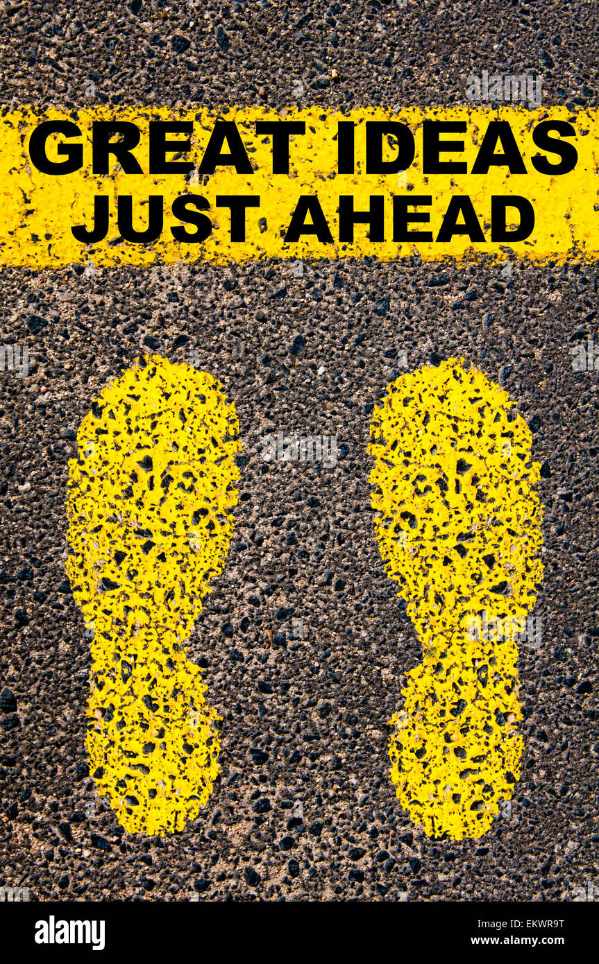 Great Ideas Just Ahead message. Conceptual image with yellow paint footsteps on the road in front of horizontal line over asphalt stone background. Stock Photo
