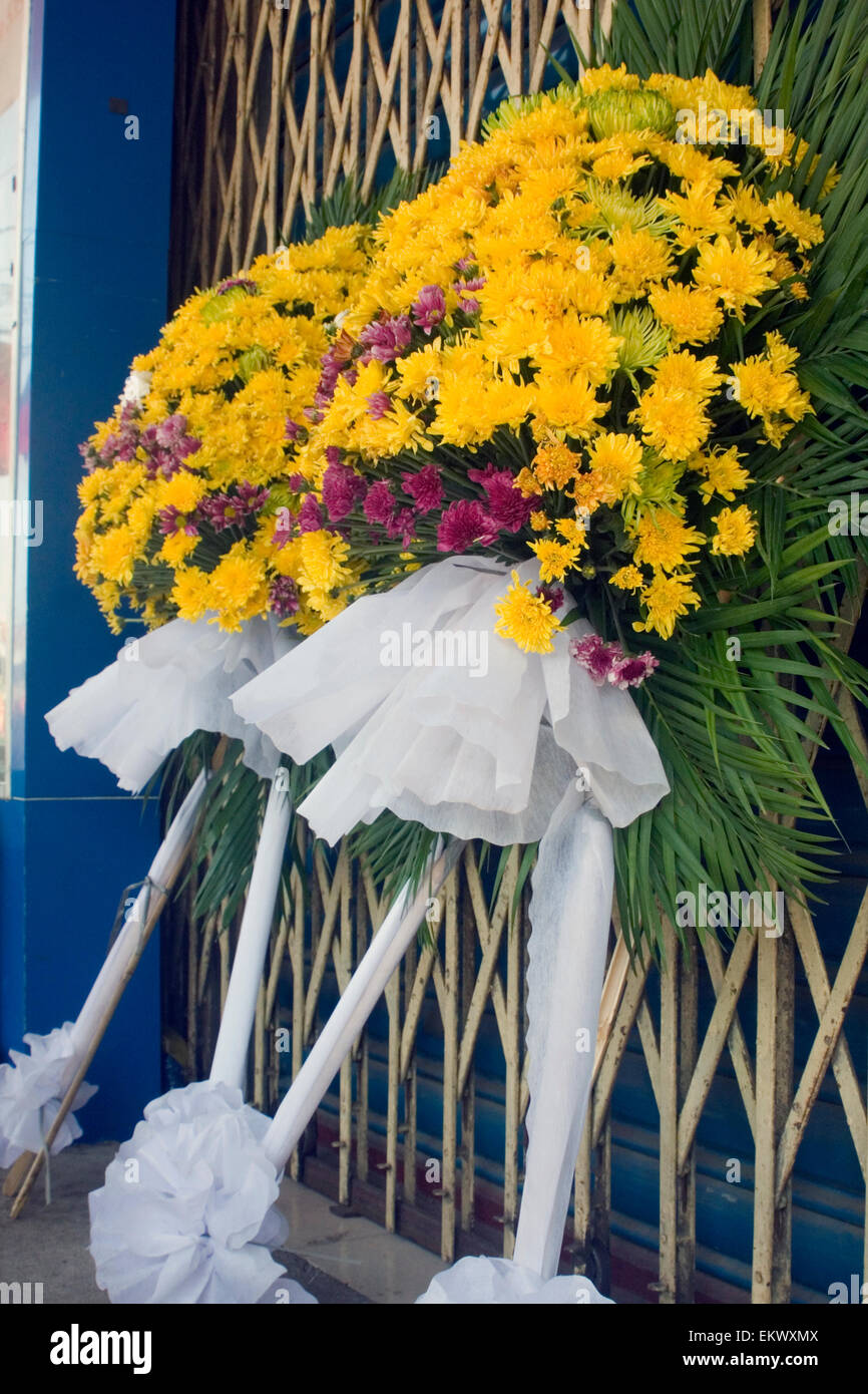 Flower wreaths used for Khmer NewYear Buddhist offerings rest for sale on a city street in Kampong Cham, Cambodia. Stock Photo