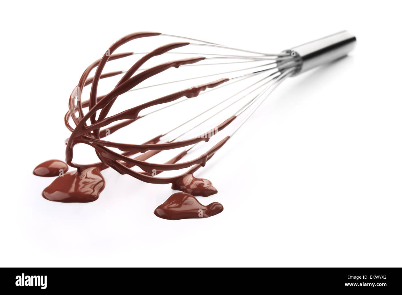 wire whisk with chocolate against white background Stock Photo