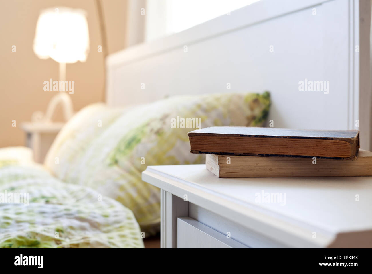 bedroom with books on nightstand Stock Photo Alamy