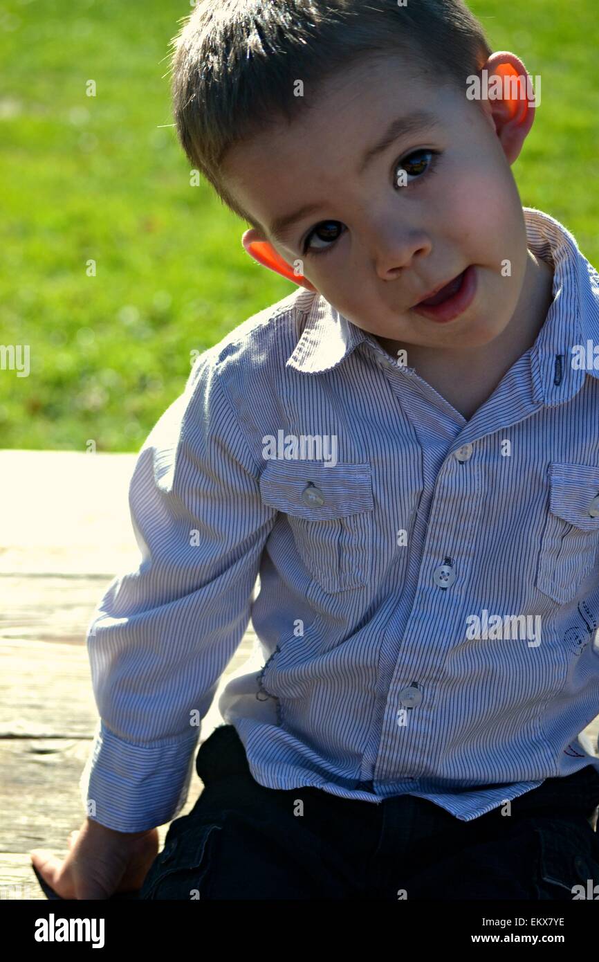 A silly 3 year old boy with big brown eyes. Stock Photo
