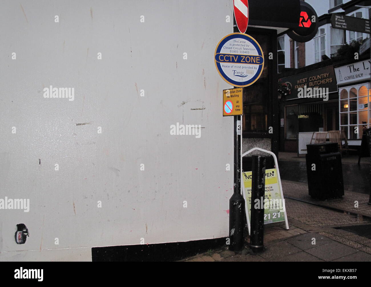 A Banksy stencil of a 'Tesco' hand grenade on a wall in a Brixham shopping street Devon Stock Photo