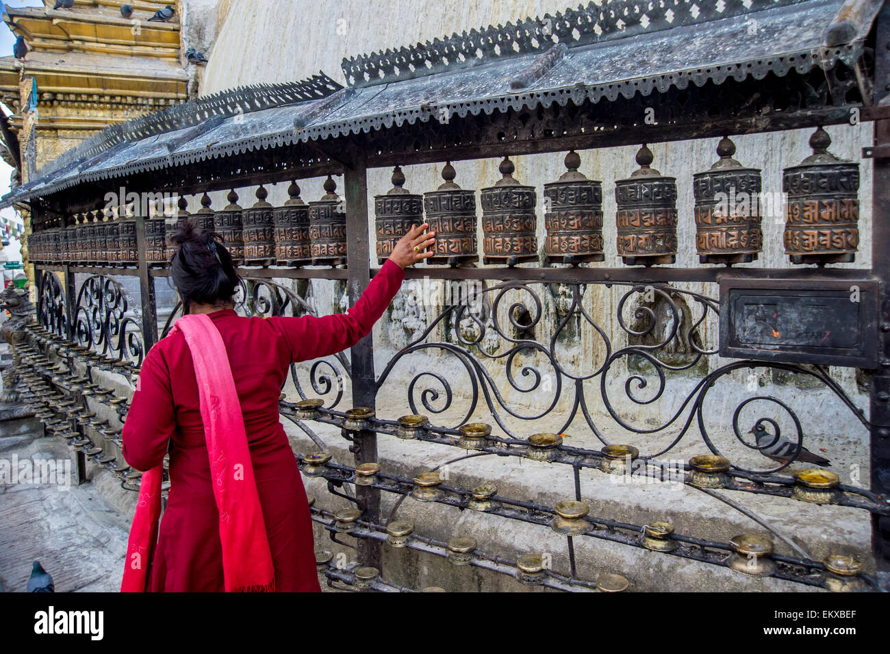 A Buddhist woman turns prayer wheels at the Stupa in Swayambhunath ...