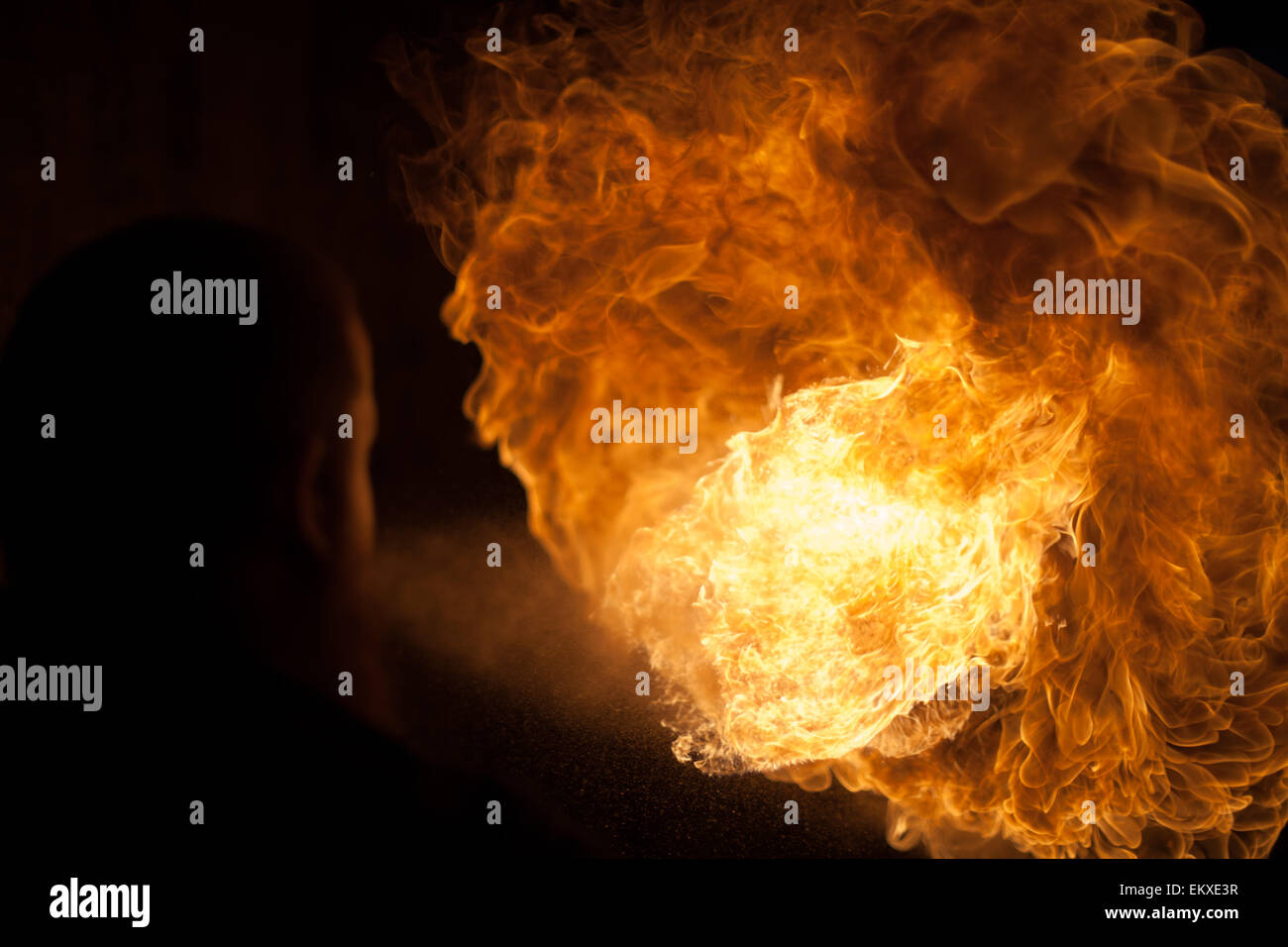 a fire breathe with a silhouetted performer figure Stock Photo