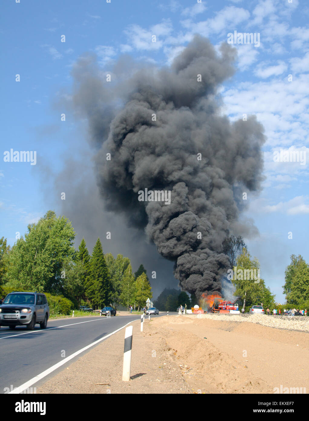 truck in fire with black smoke on the road Stock Photo