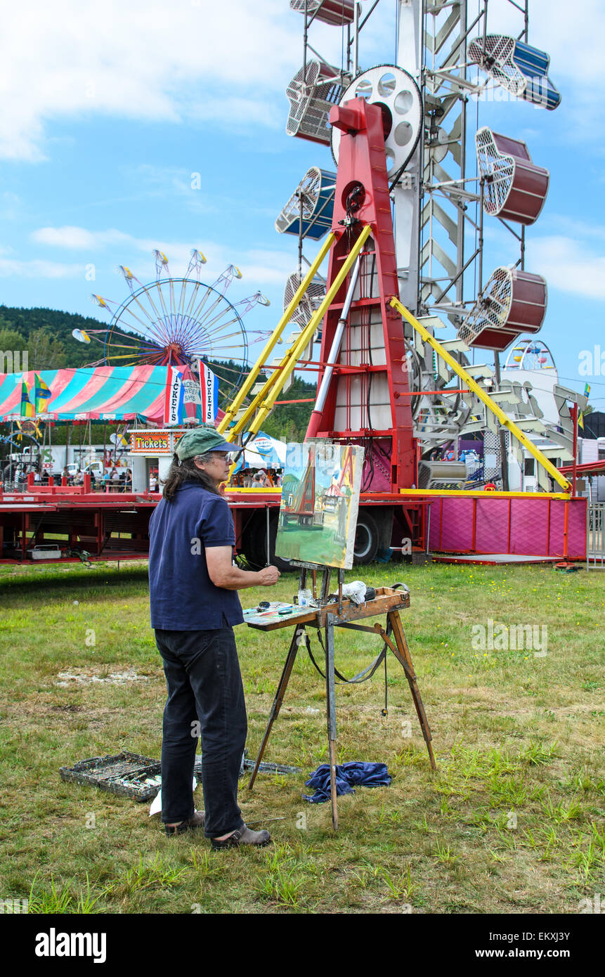 An artist paints the carnival rides at the Blue Hill Fair, Maine Stock