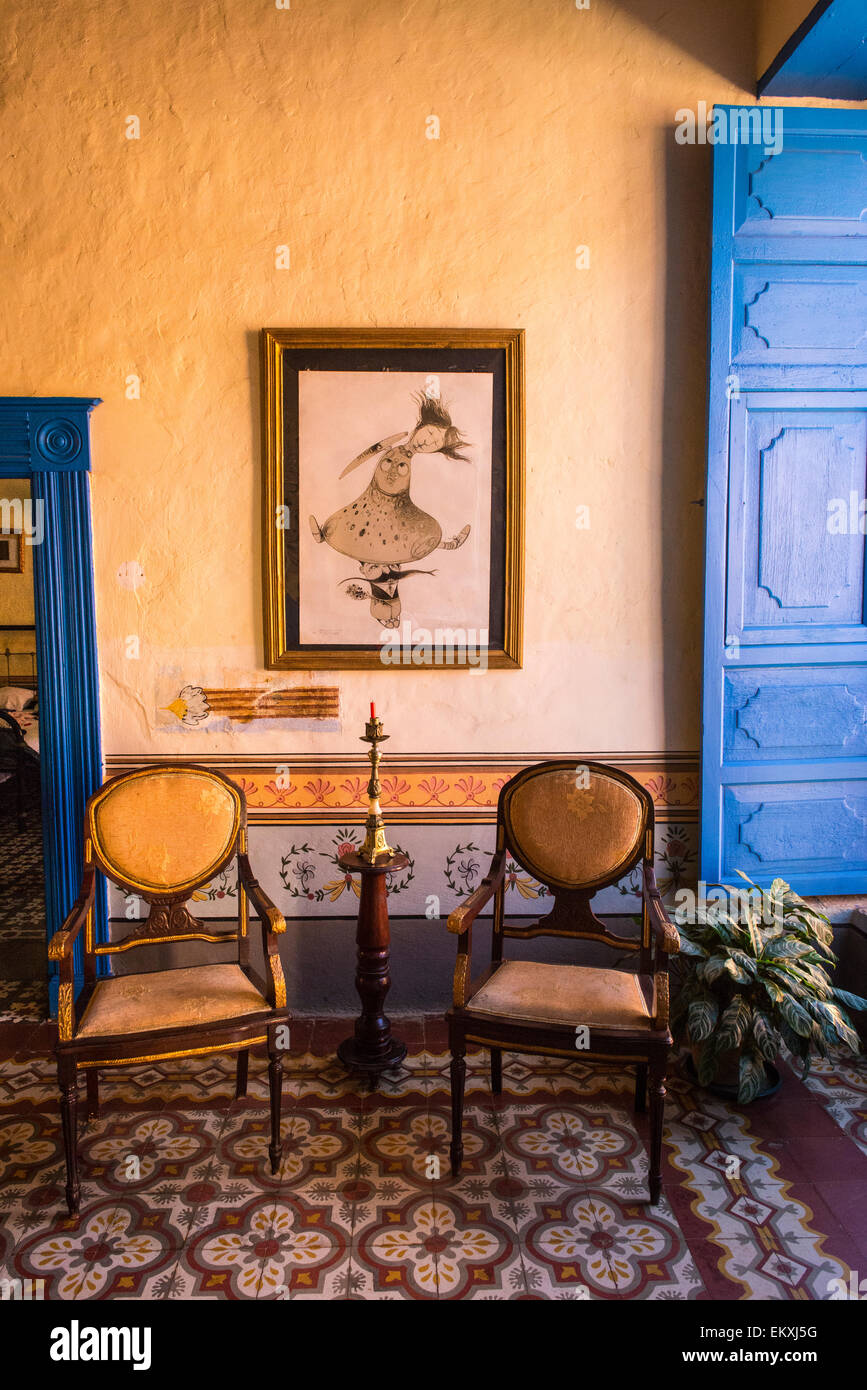 Cuba Trinidad Typical Cuban Home Sitting Room Antique Chairs Stock Cuba Trinidad typical Cuban home sitting room antique chairs candlestick blue shutters painting ornate walls & tile tiles - Cuba Trinidad Typical Cuban Home Sitting Room Antique Chairs Stock