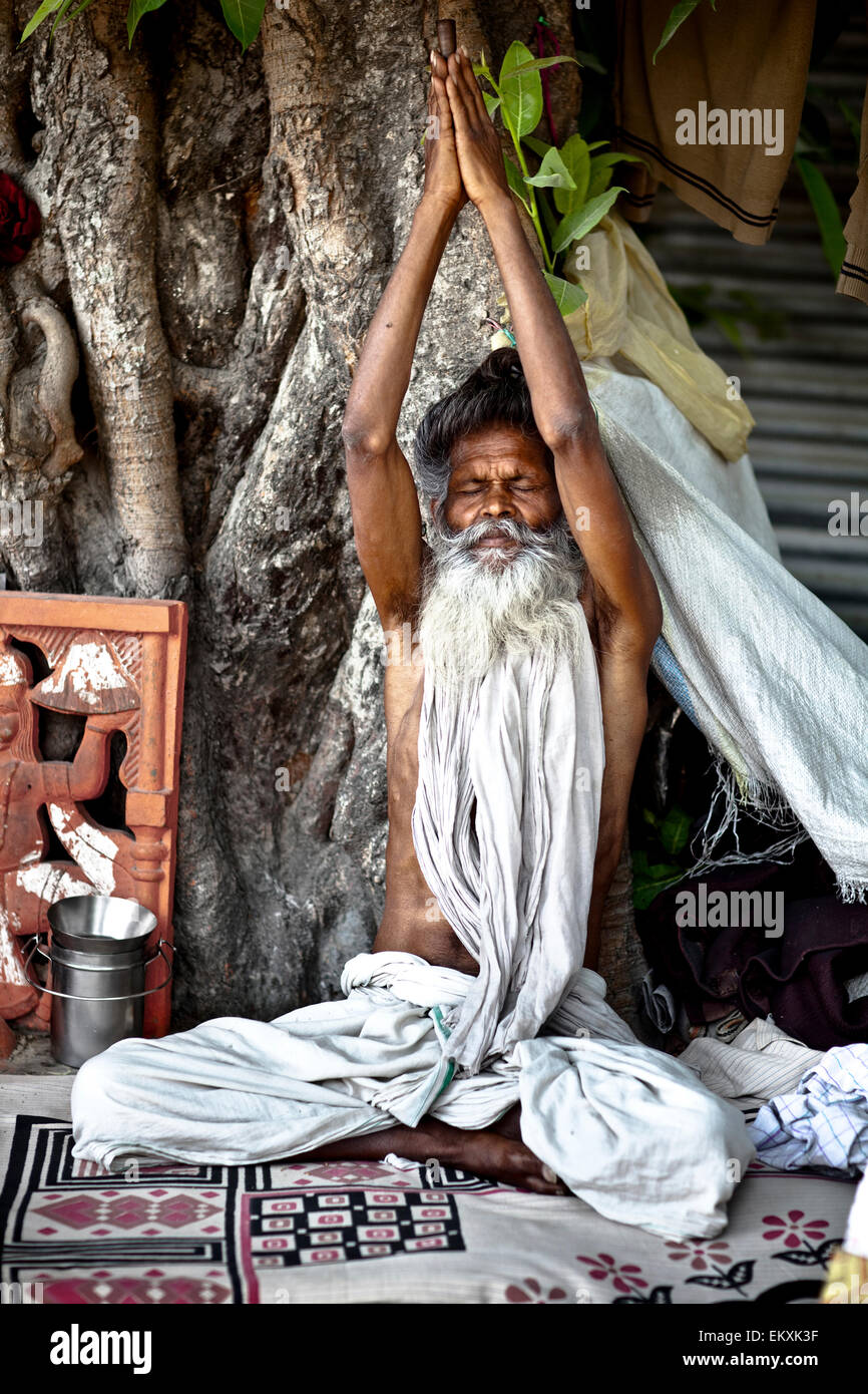 A Holy Man Sits With Eyes Closed And Arms Raised; Haridwar India Stock Photo