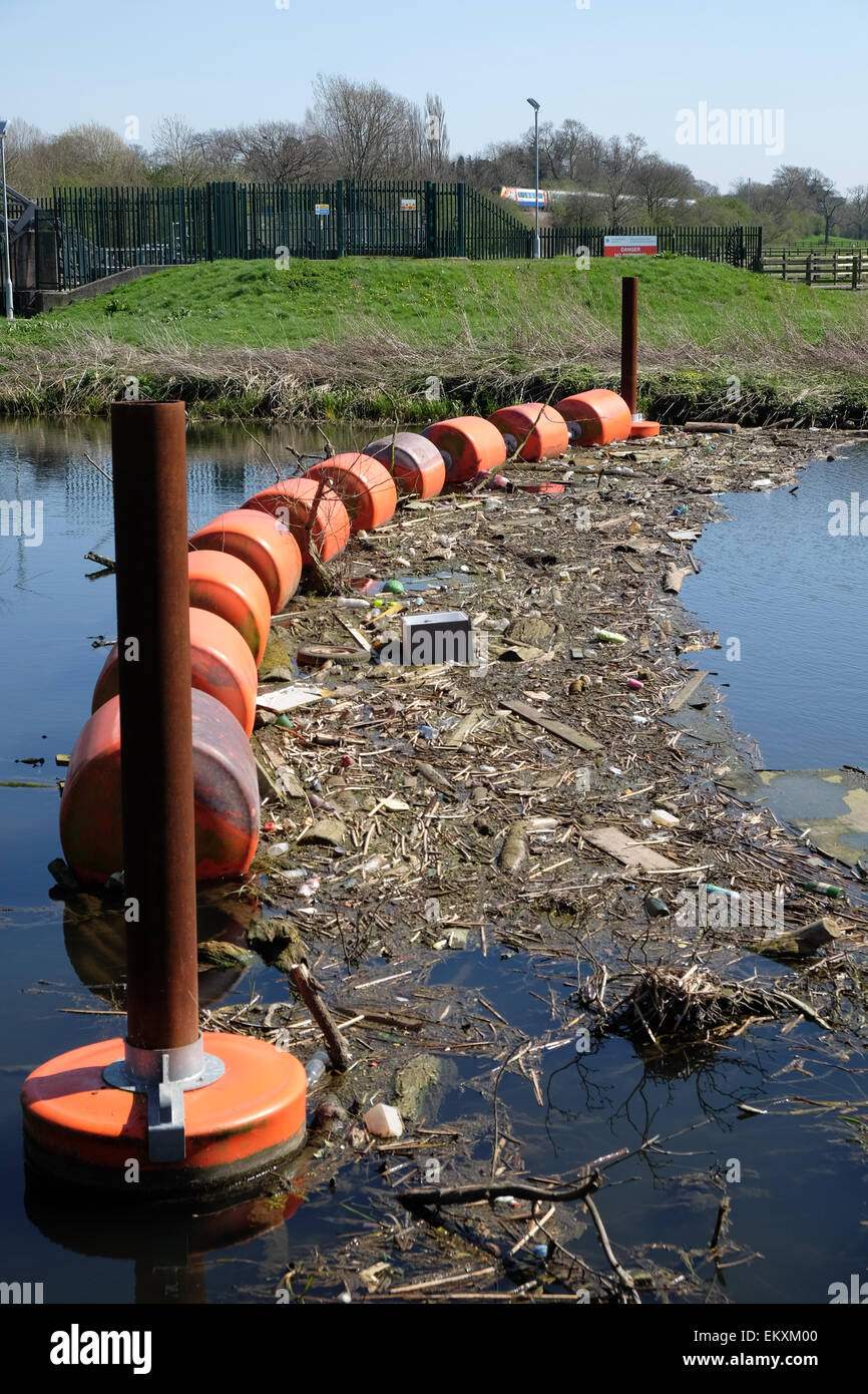 Rubbish that has flowed down river is caught on a barrier across the ...