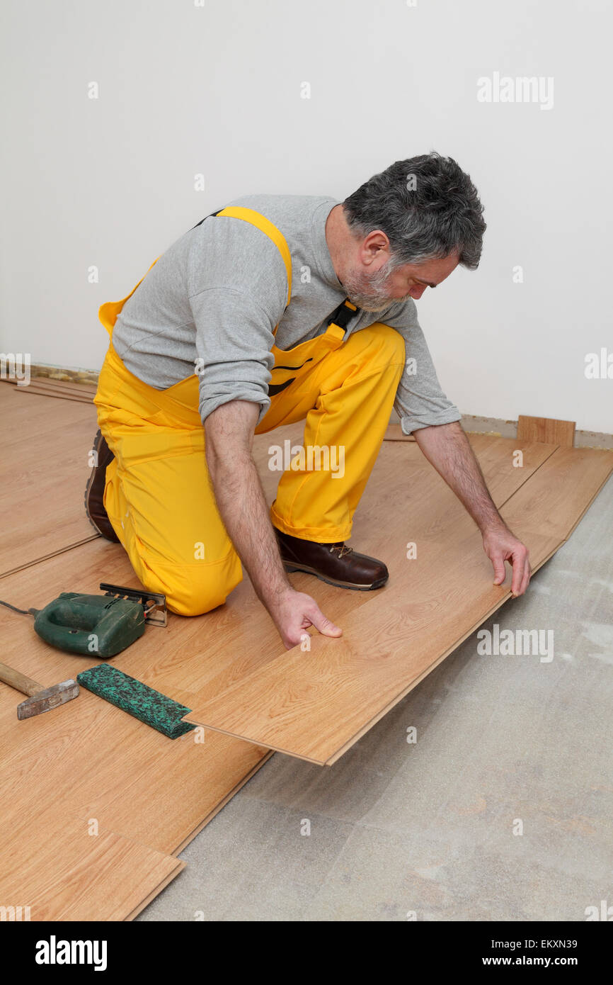 Adult Male Worker Installing Laminate Floor Floating Wood