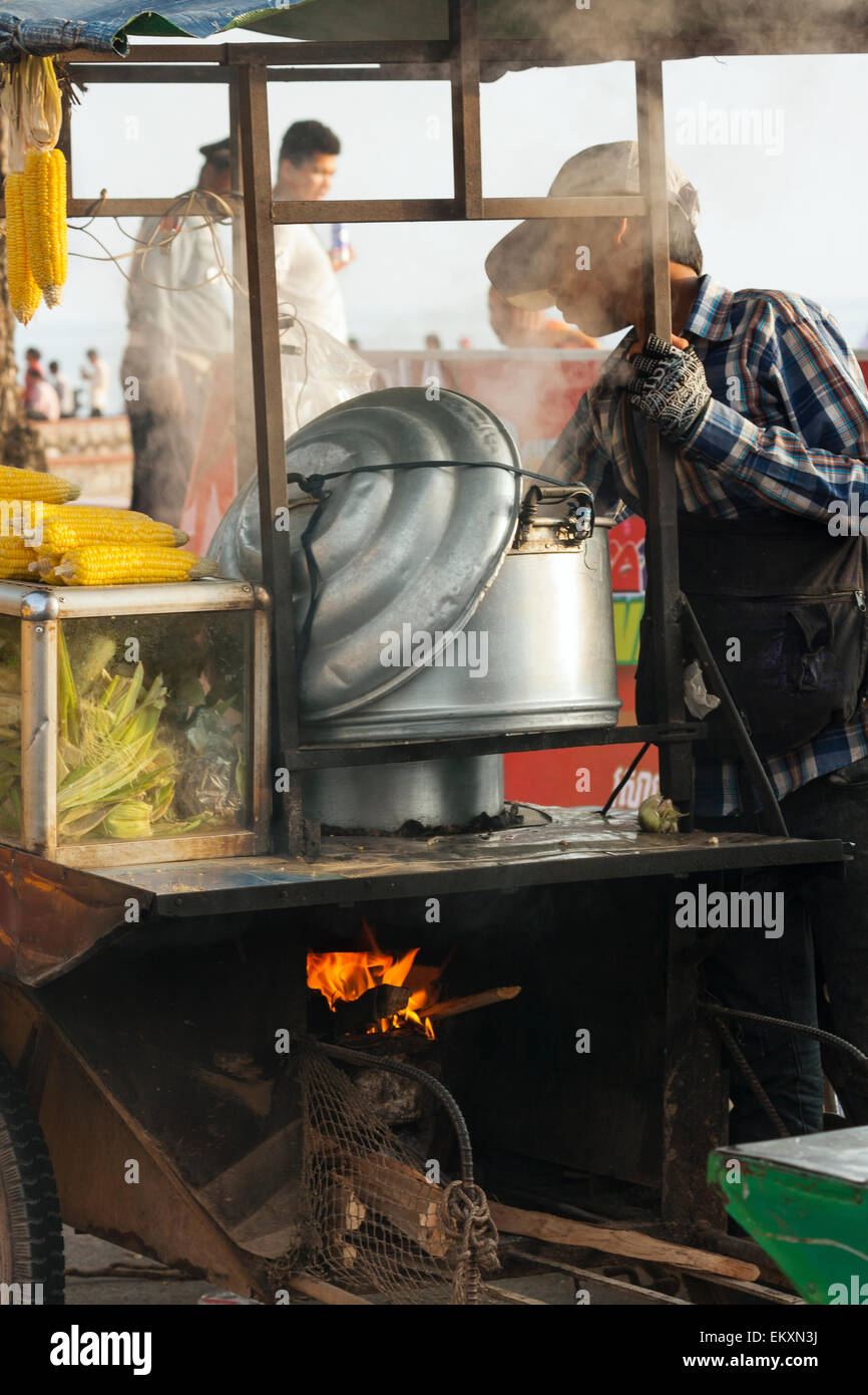 A boy boiling and selling corn cobs in Kep, Cambodia, Asia. Stock Photo