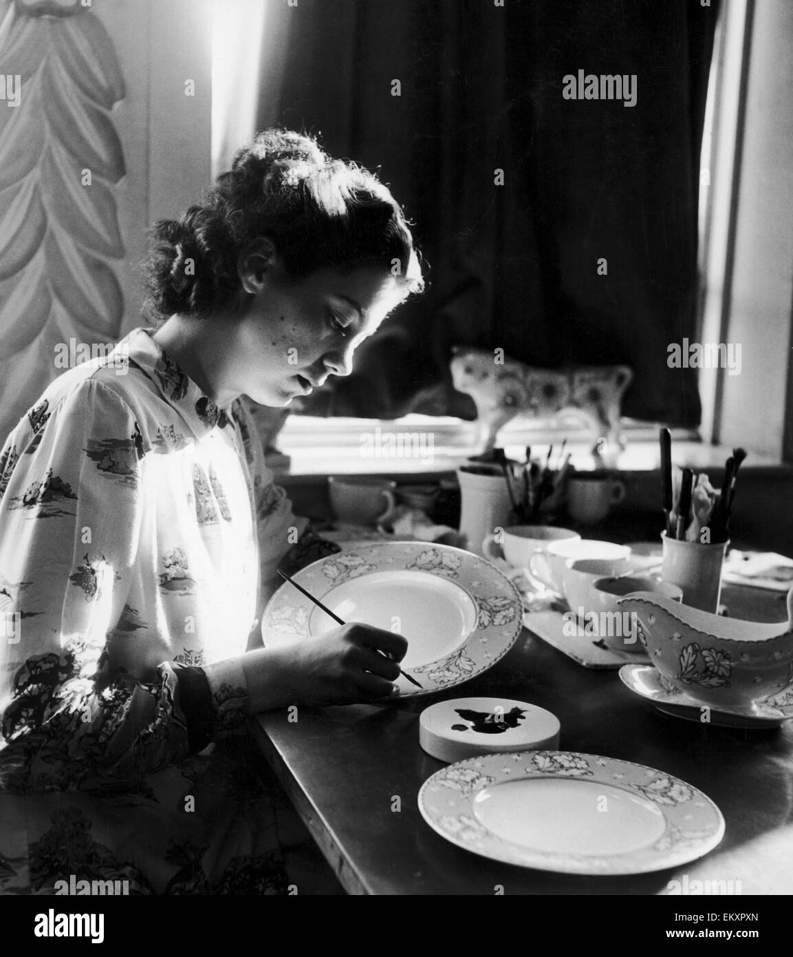 Olwyn Cotgreave, aged 20, tracing in platinum the outline of the flower design on a dessert plate, one piece in the huge 161 piece dinner set ordered by the King and Queen of England for M and Mme Auriol. All the pieces are being painted by free-hand pain Stock Photo