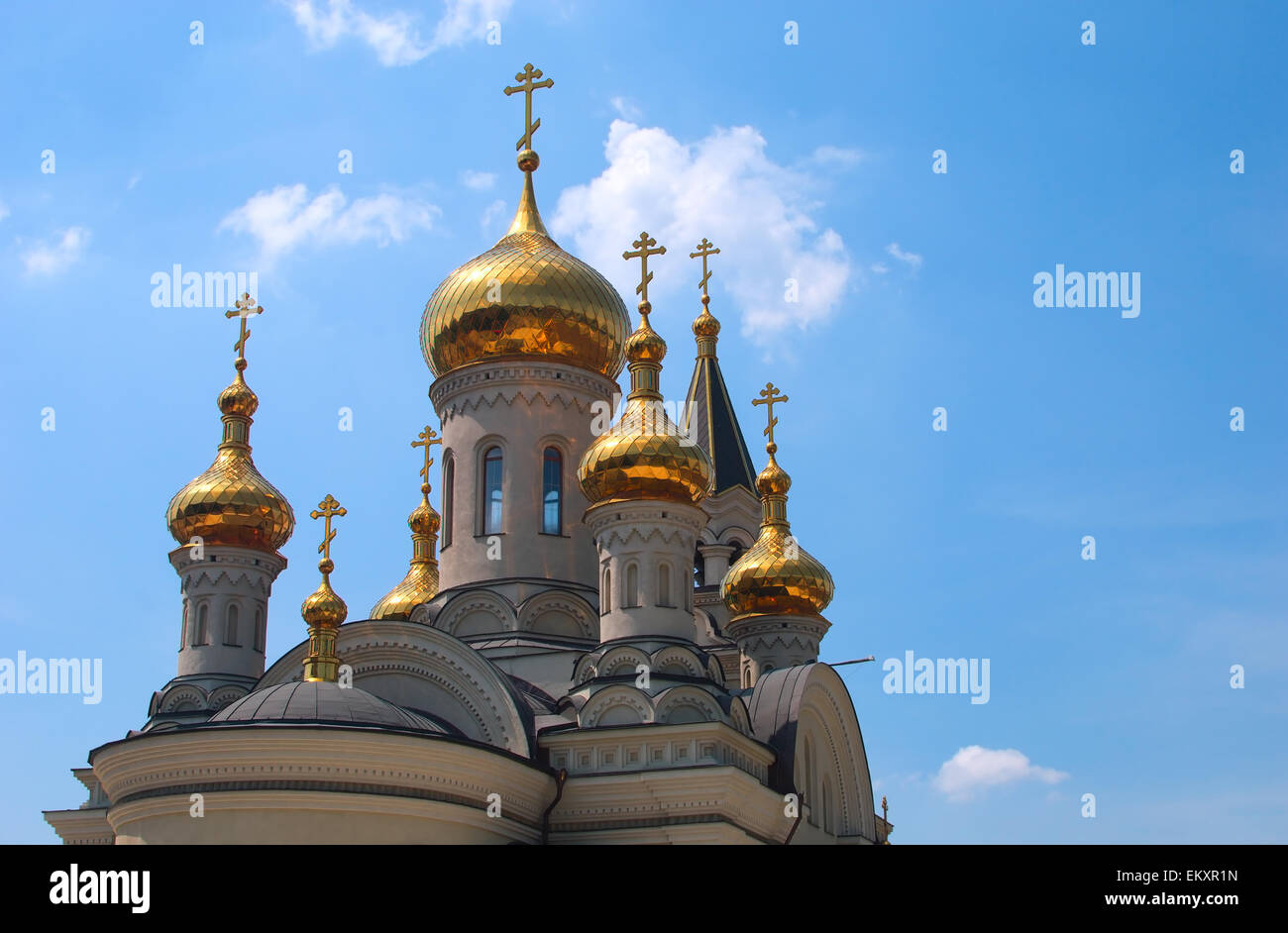Golden domes of Orthodox Cathedral in Donetsk, blue sky in the background Stock Photo