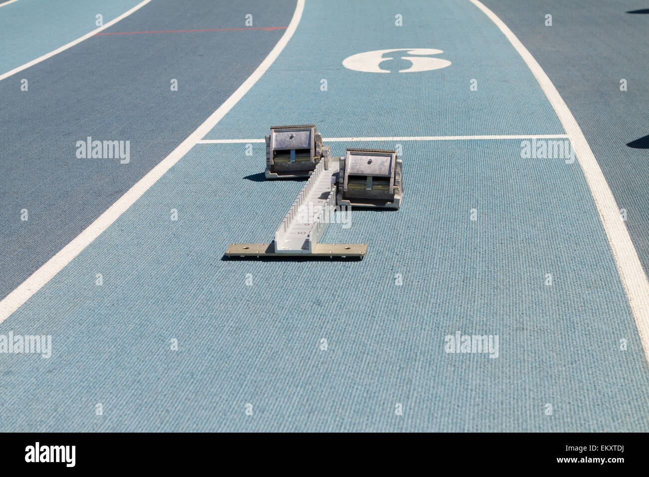 Blue mondo surface running track lanes with starting blocks Stock Photo