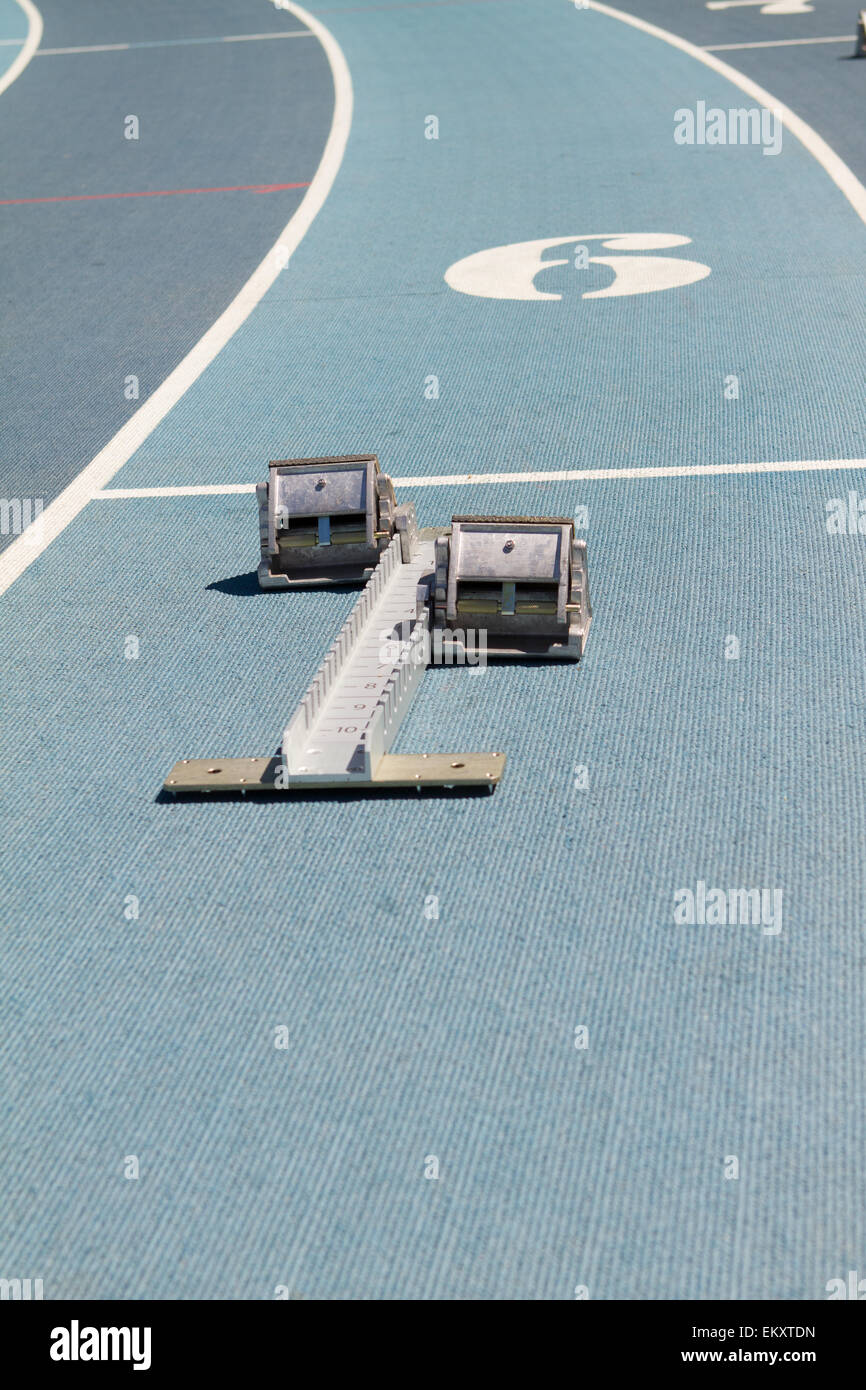 Blue mondo surface running track lanes with starting blocks Stock Photo