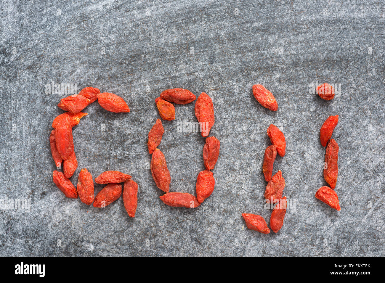 Goji word made from dry red berries on blackboard surface Stock Photo