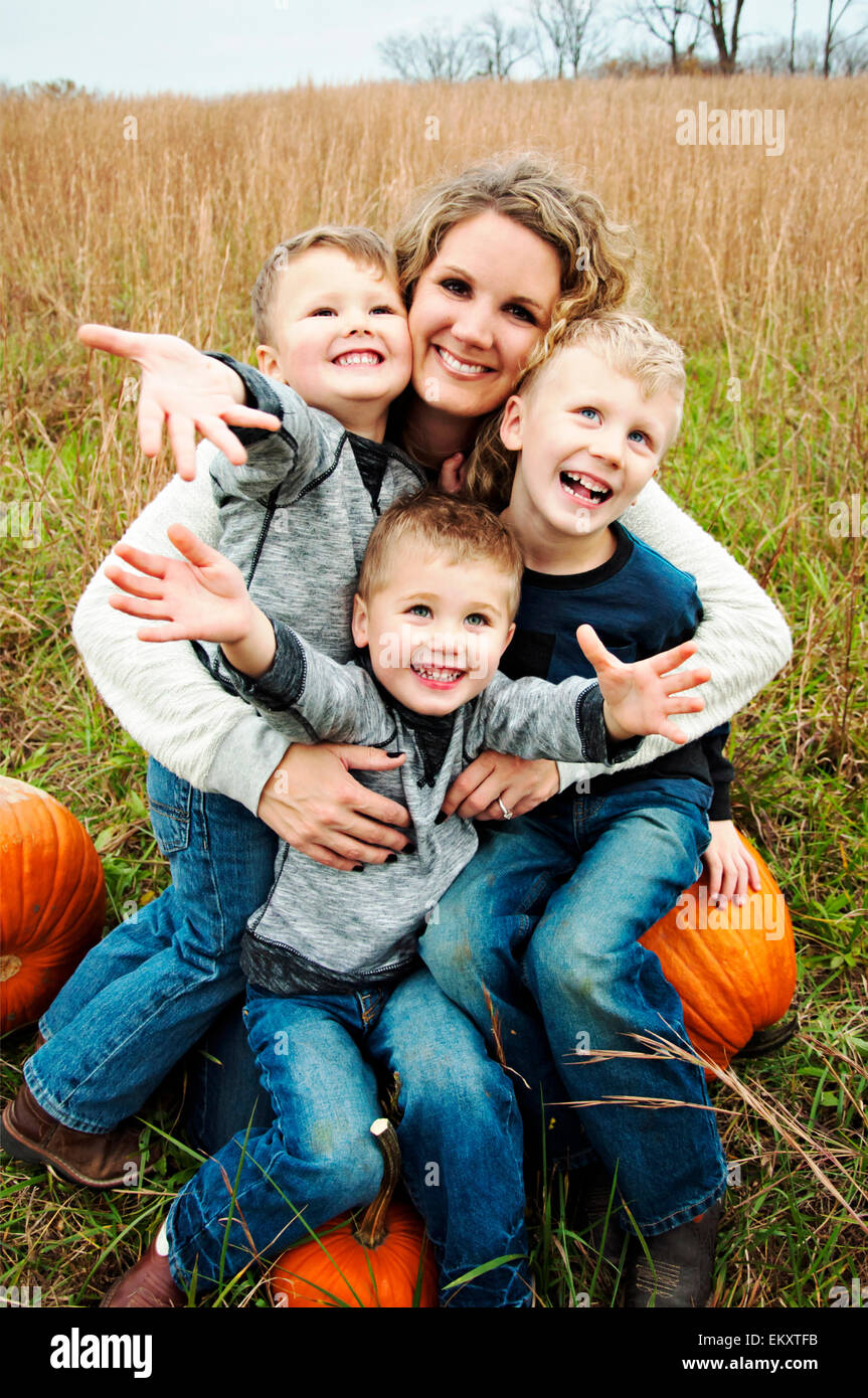 Mother holding three boys in her arms Stock Photo