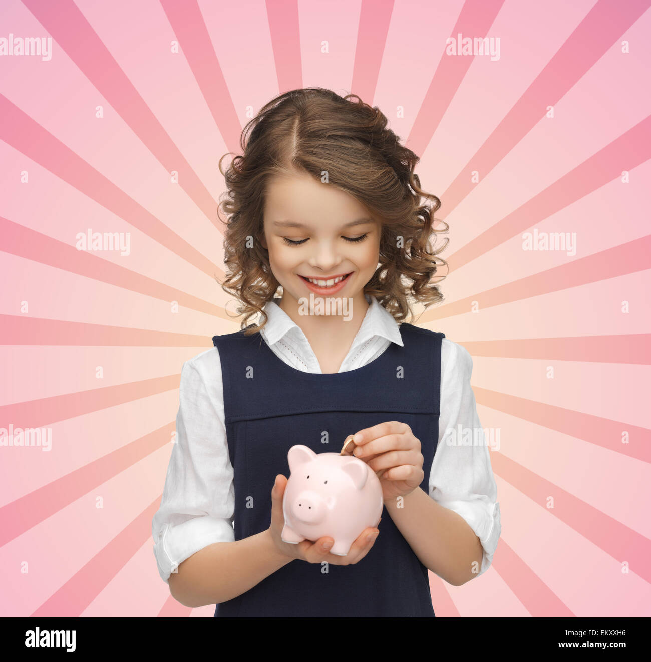 happy girl putting coin into piggy bank Stock Photo - Alamy