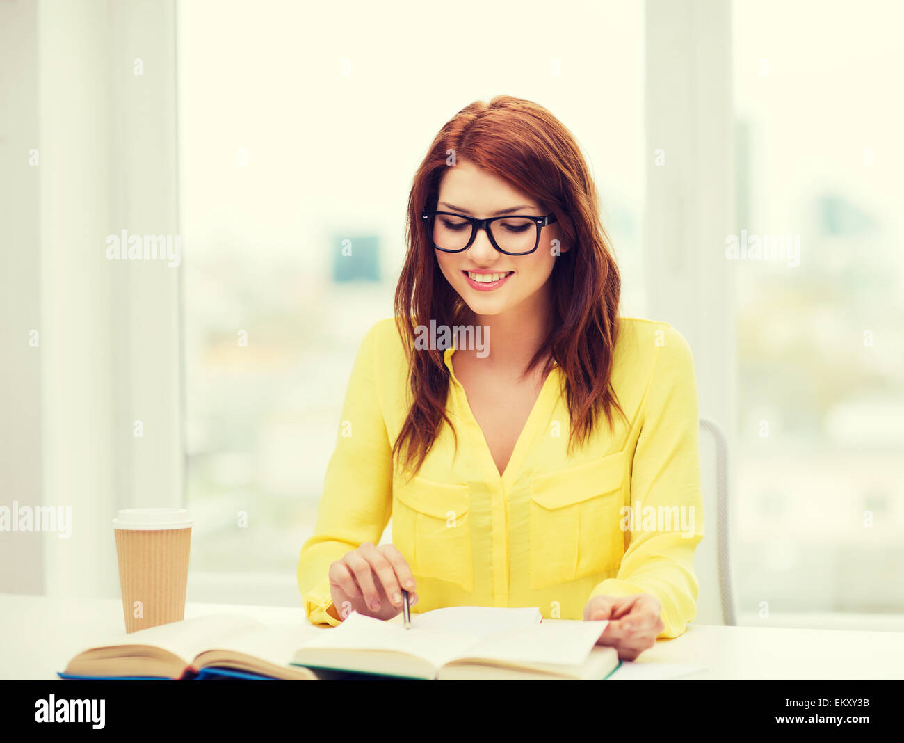 smiling student girl reading books in library Stock Photo - Alamy