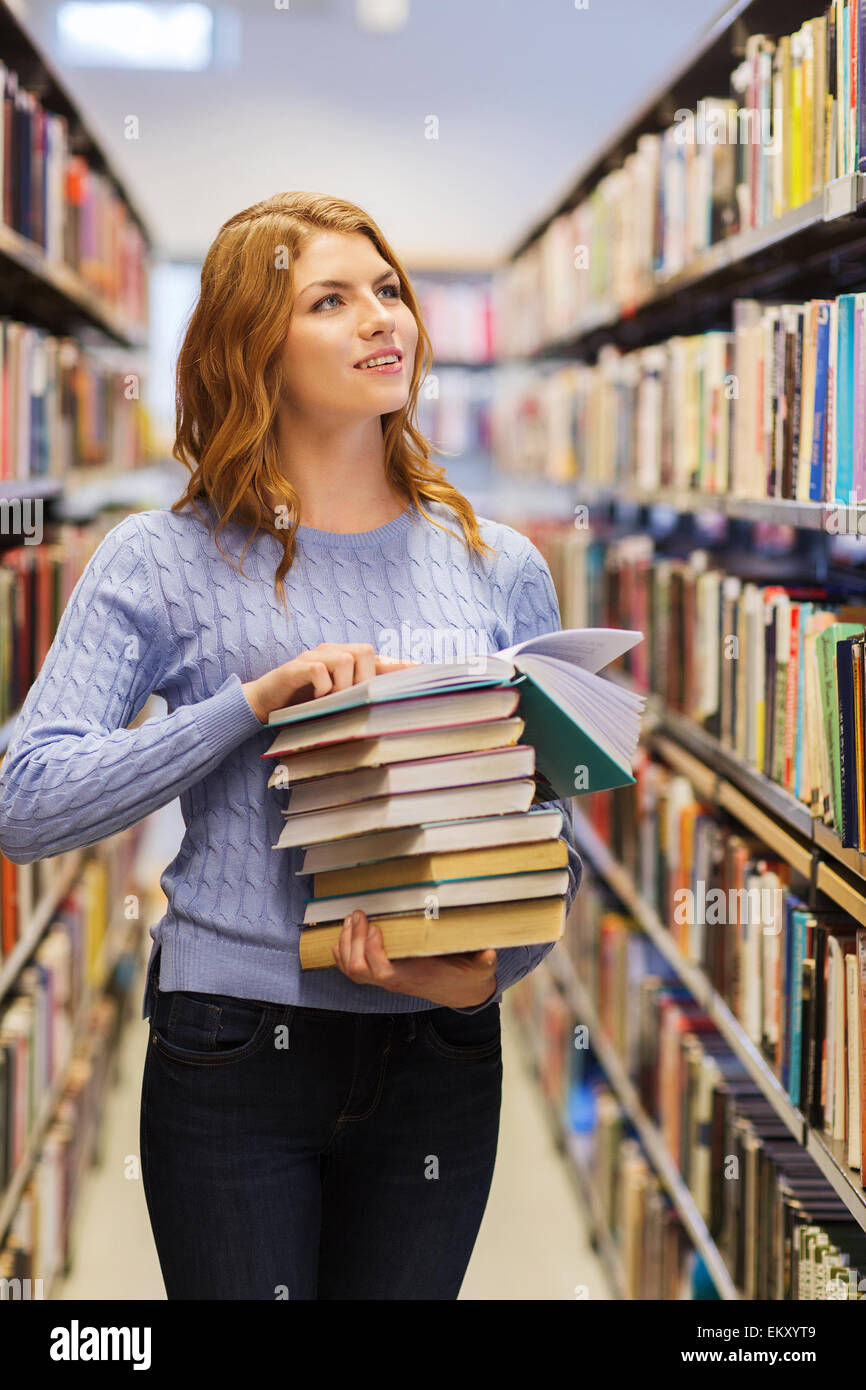 happy student girl or woman with books in library Stock Photo - Alamy