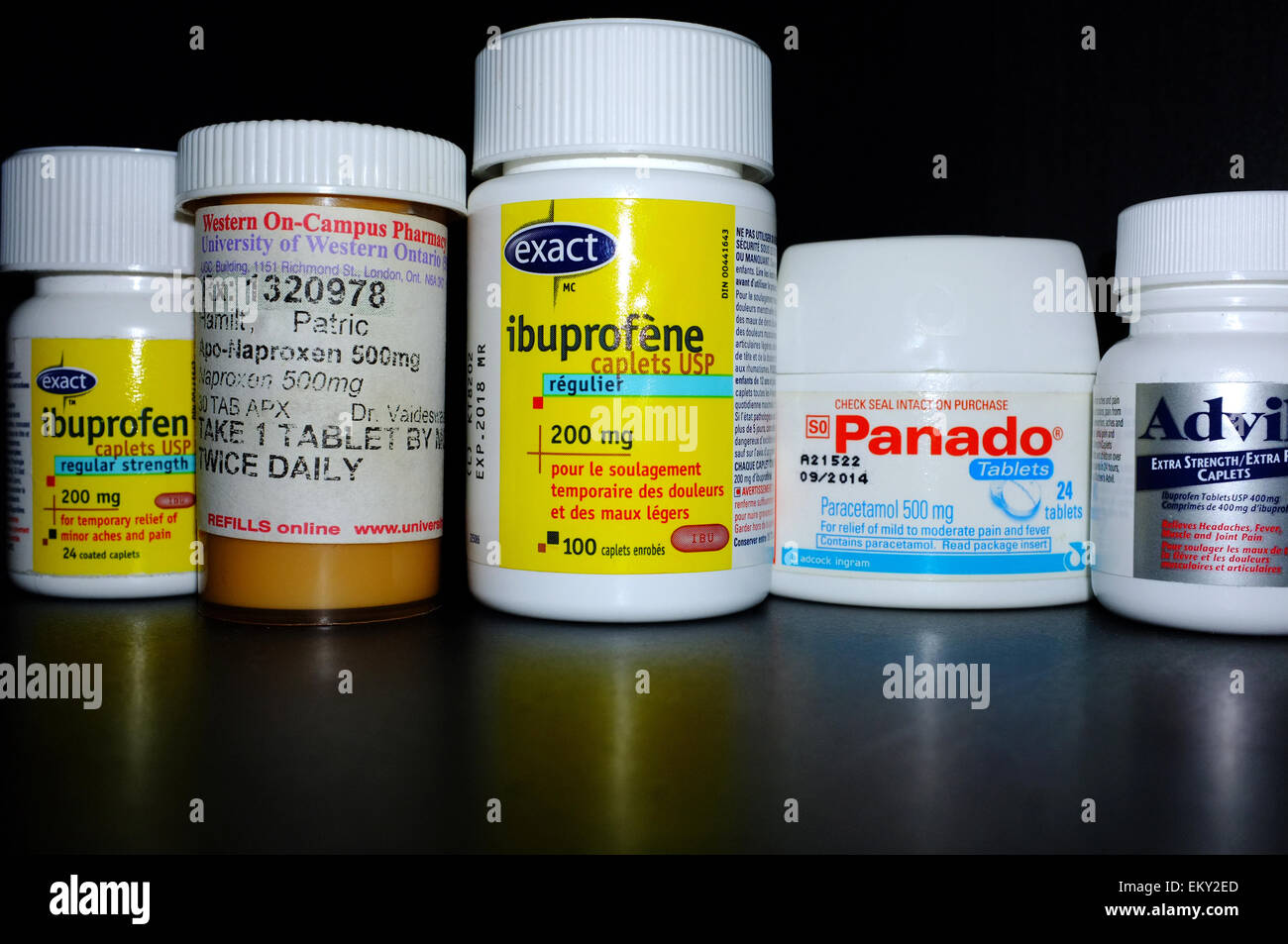 A selection of pain killer bottles photographed against a black background. Stock Photo