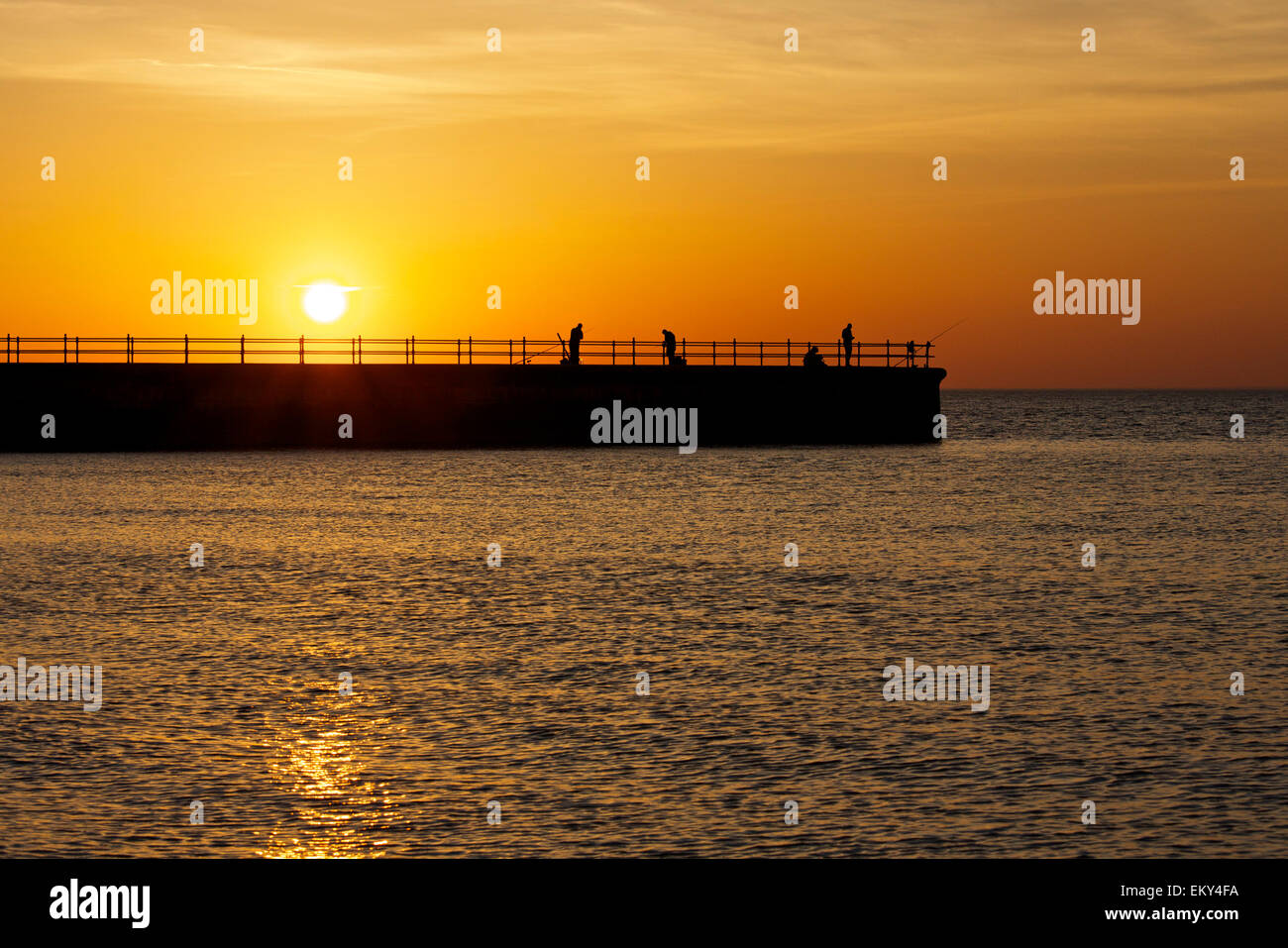 Hampton, Kent, UK. 14th April 2015: UK Weather. Sunset at Hampton near Herne Bay in Kent as anglers fish from the pier, making the most of the last rays of light after a glorious hot day with more good weather forecast for Wednesday Stock Photo