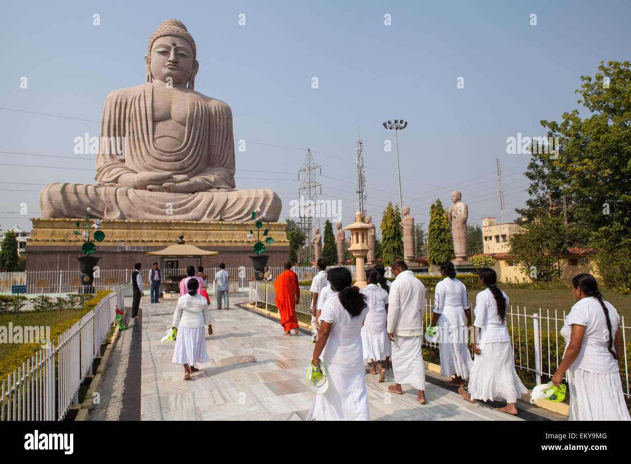 Pilgrims walk towards the Great Buddha statue at Bodhgaya Stock Photo