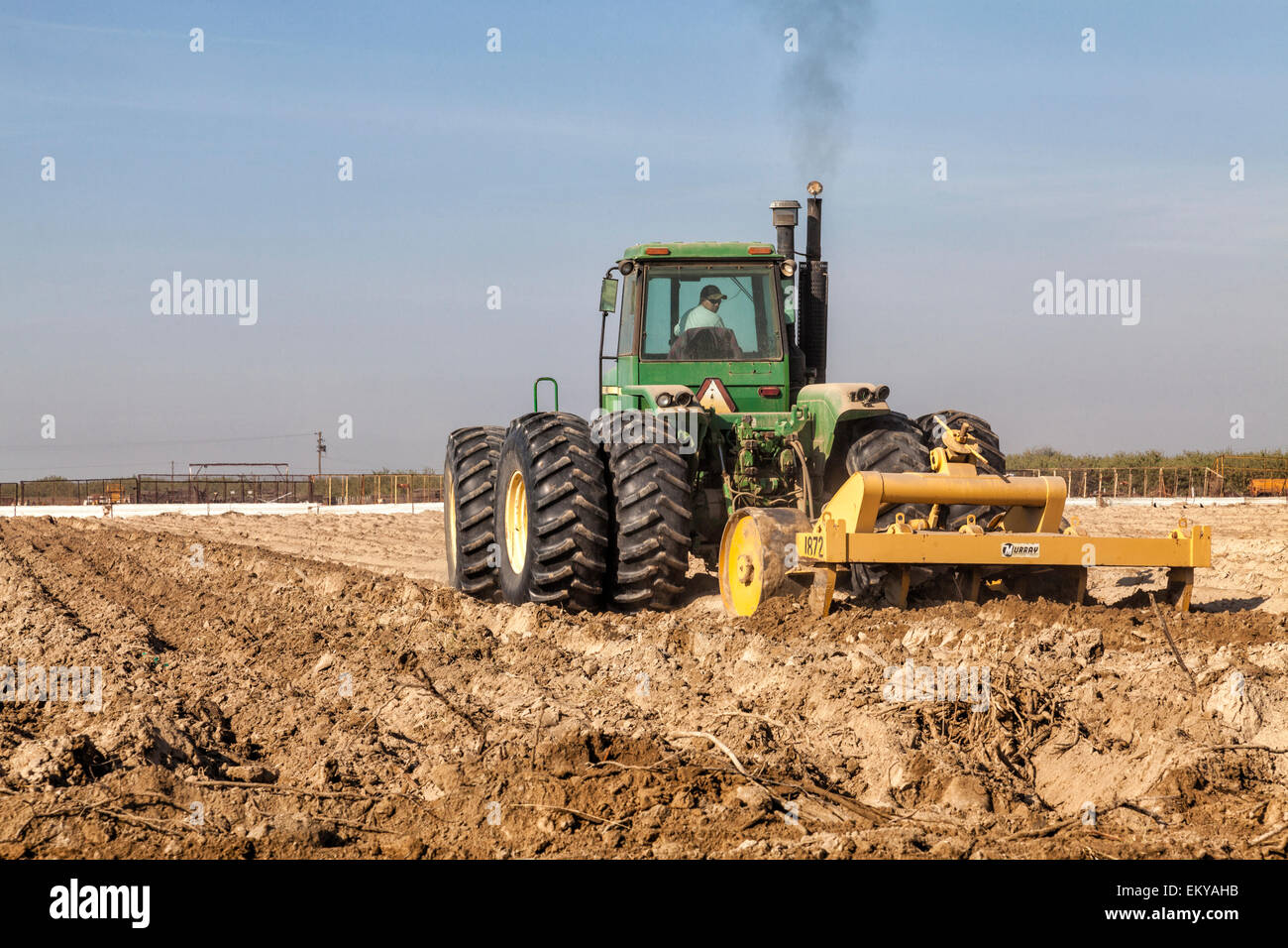 Tractor hoeing crop field for planting. Fresno County, San Joaquin