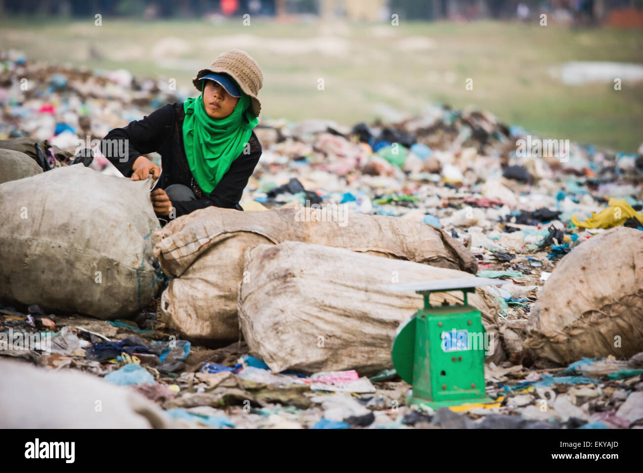 Cambodia, Woman with plastic sacks in city trash dump; Phnom Penh Stock Photo