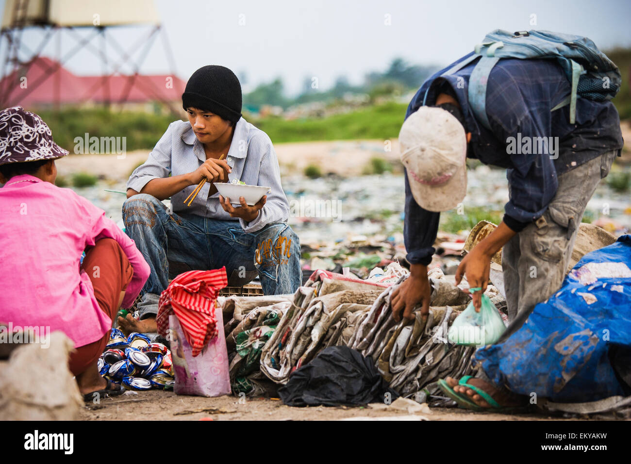 Cambodia, Men pause for meal in city trash dump; Pnhom Penh Stock Photo
