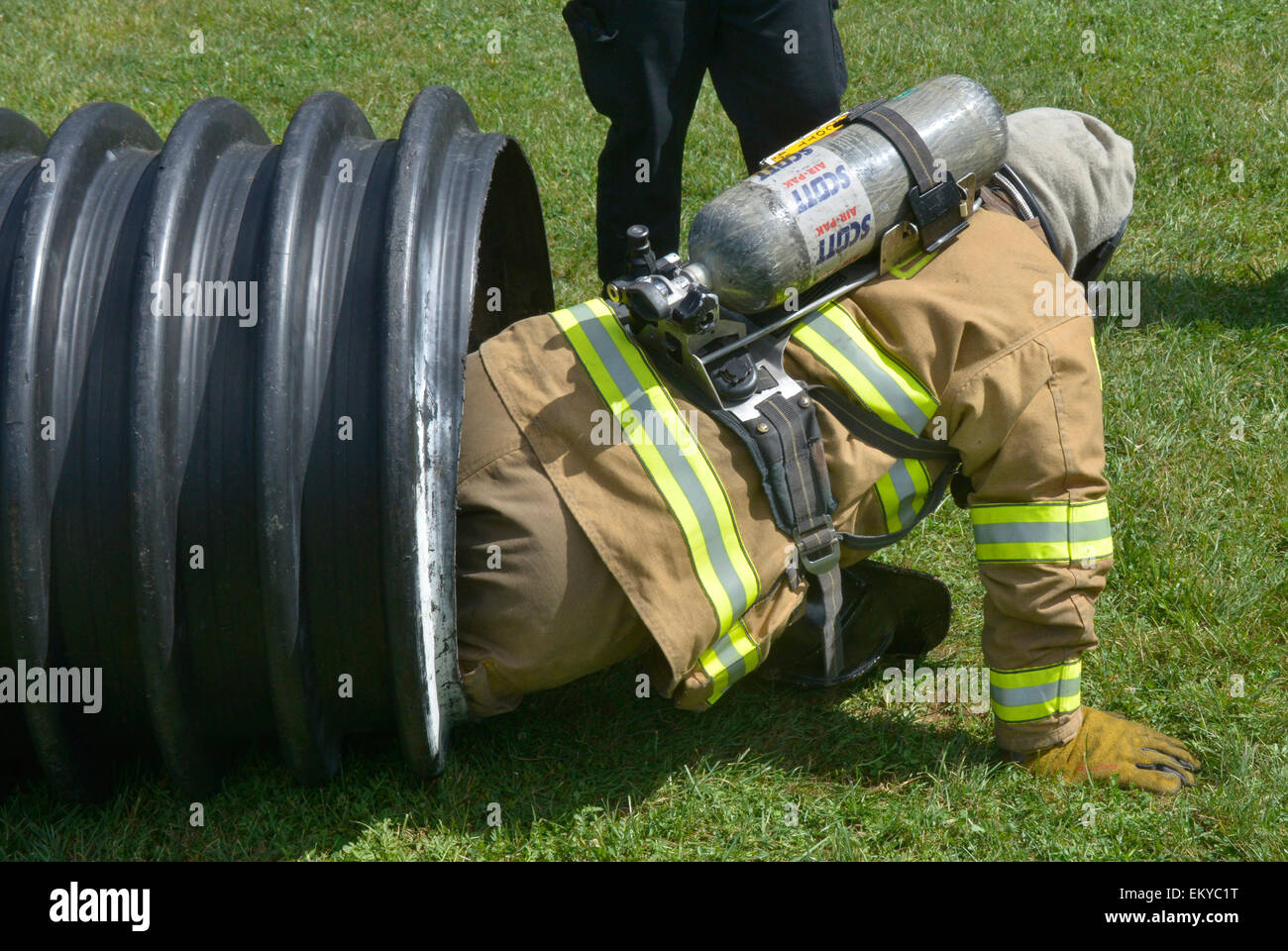 firefighter drills by crawling through a rubber drain pipe Stock Photo